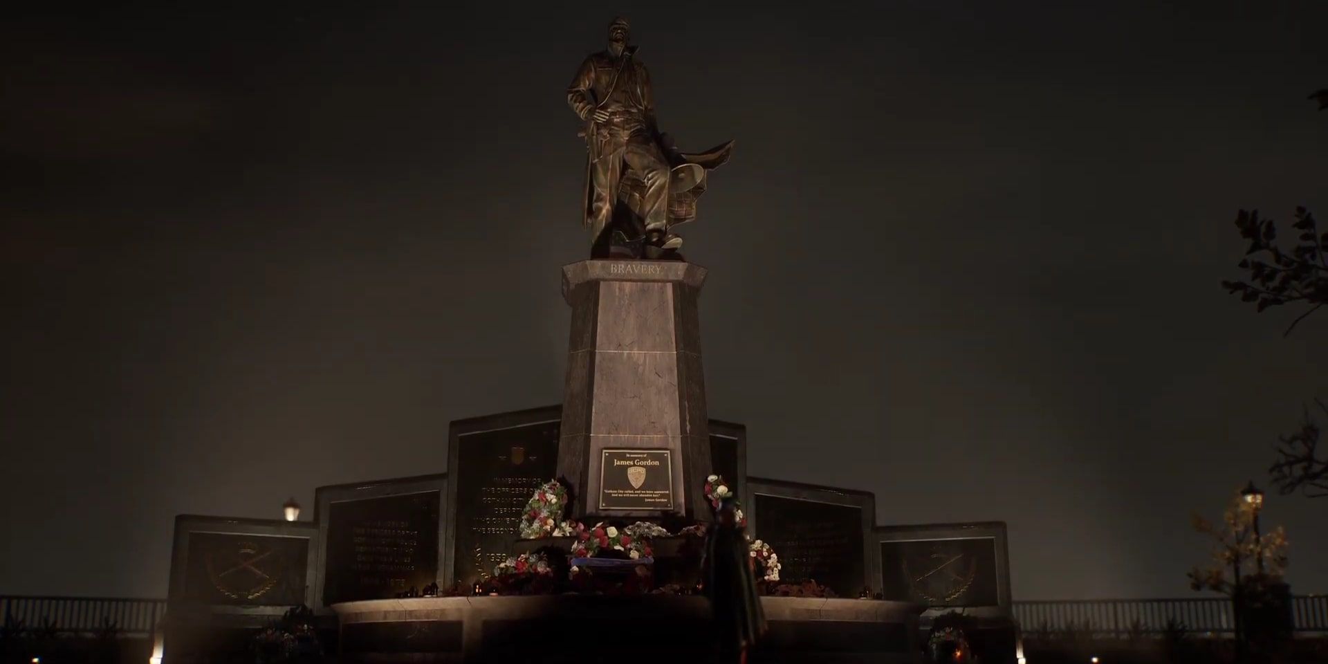 Screenshot of  Barbara looking up at the Jim Gordon Memorial in a Gotham Knights cinematic.