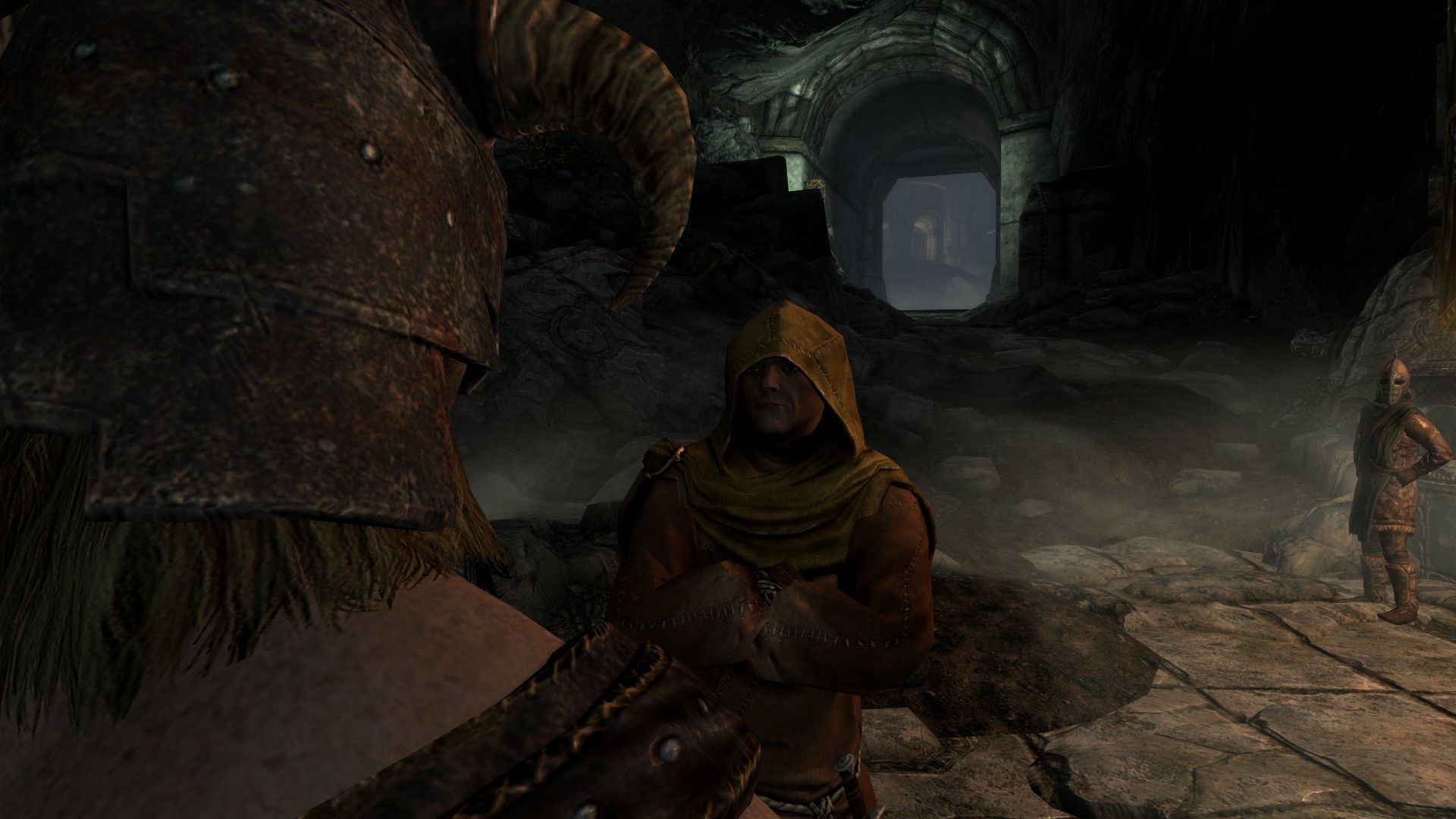 An adventurer speaks to a robed priest inside a large stone keep.