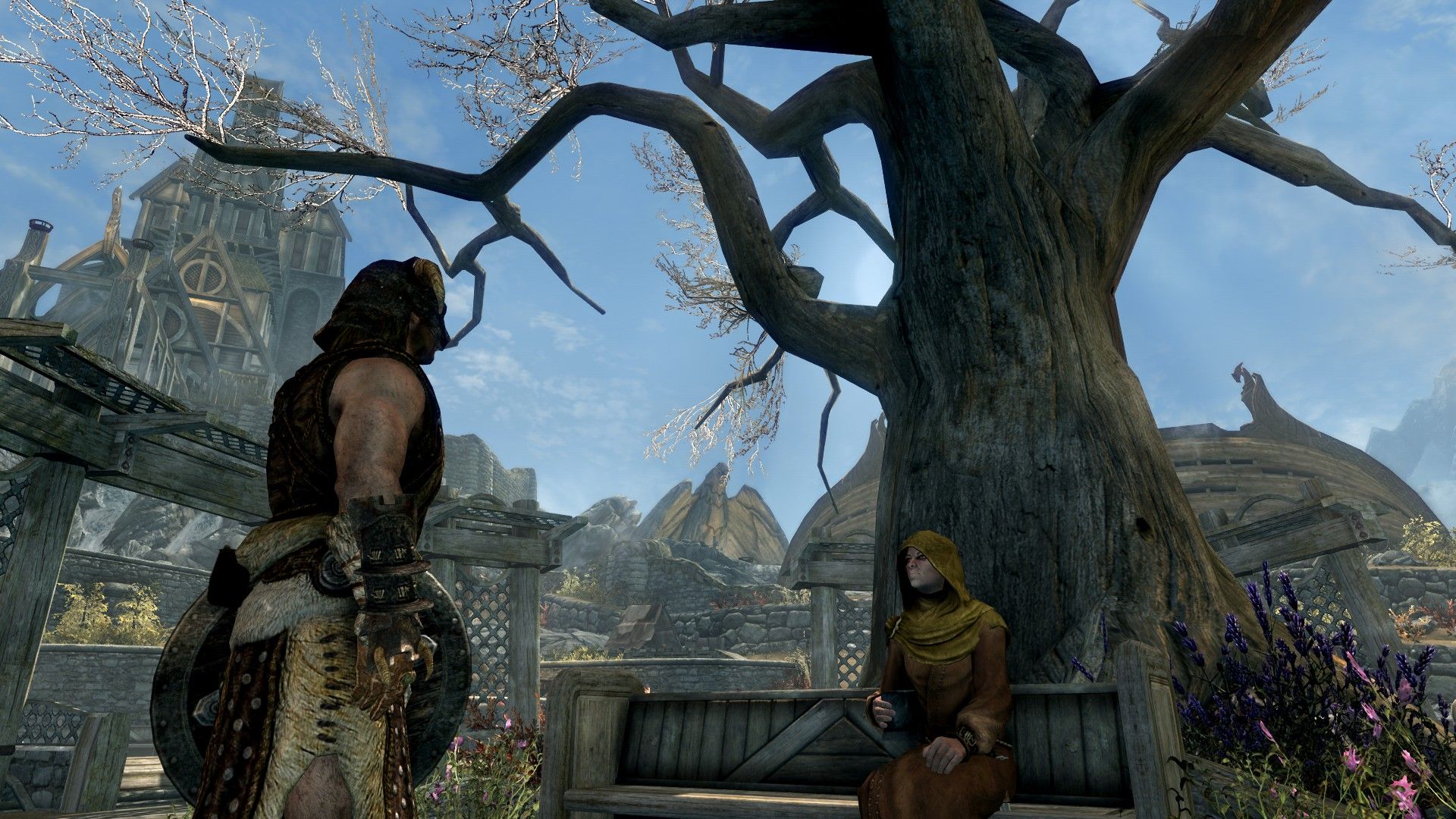 A man speaks to a priestess by the dried-out trunk of a dying tree in the center of a rustic city.