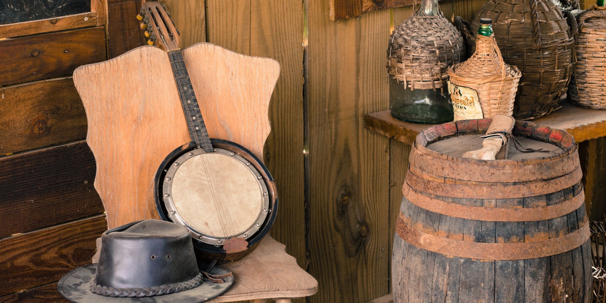 Western Style Decorations decorate a wall, including a barrel, banjo, and wicker bottles.