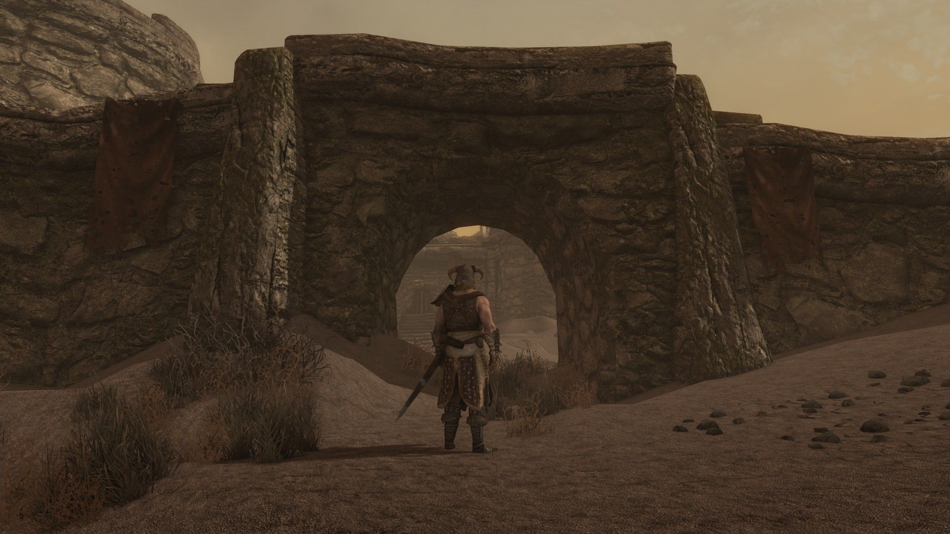 An armed and armored man stands at the entrance of a battered and crumbling palace surrounded by deep ashes.