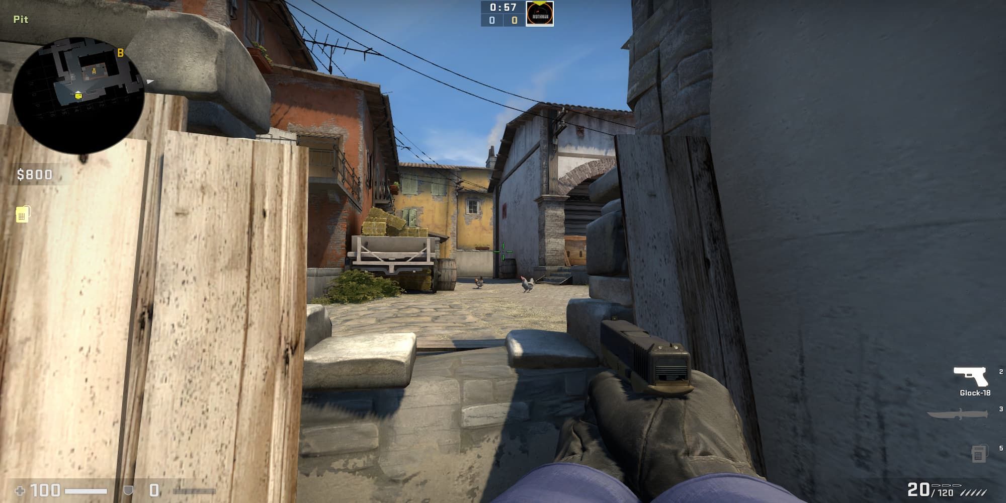The CS:GO player peeks through the broken wall at the Pit on Inferno.
