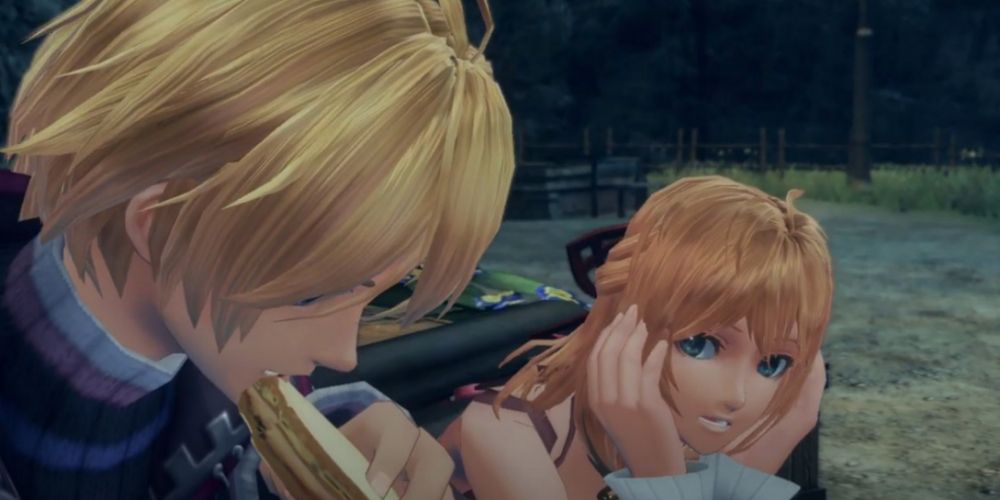 Shulk eats a sandwich while Fiora looks on with her hands on either side of her head.
