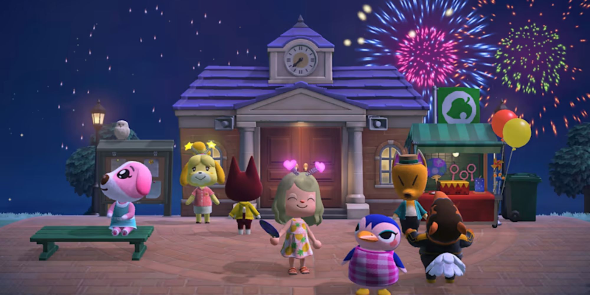A group of villagers gather in the square as fireworks explode in the sky
