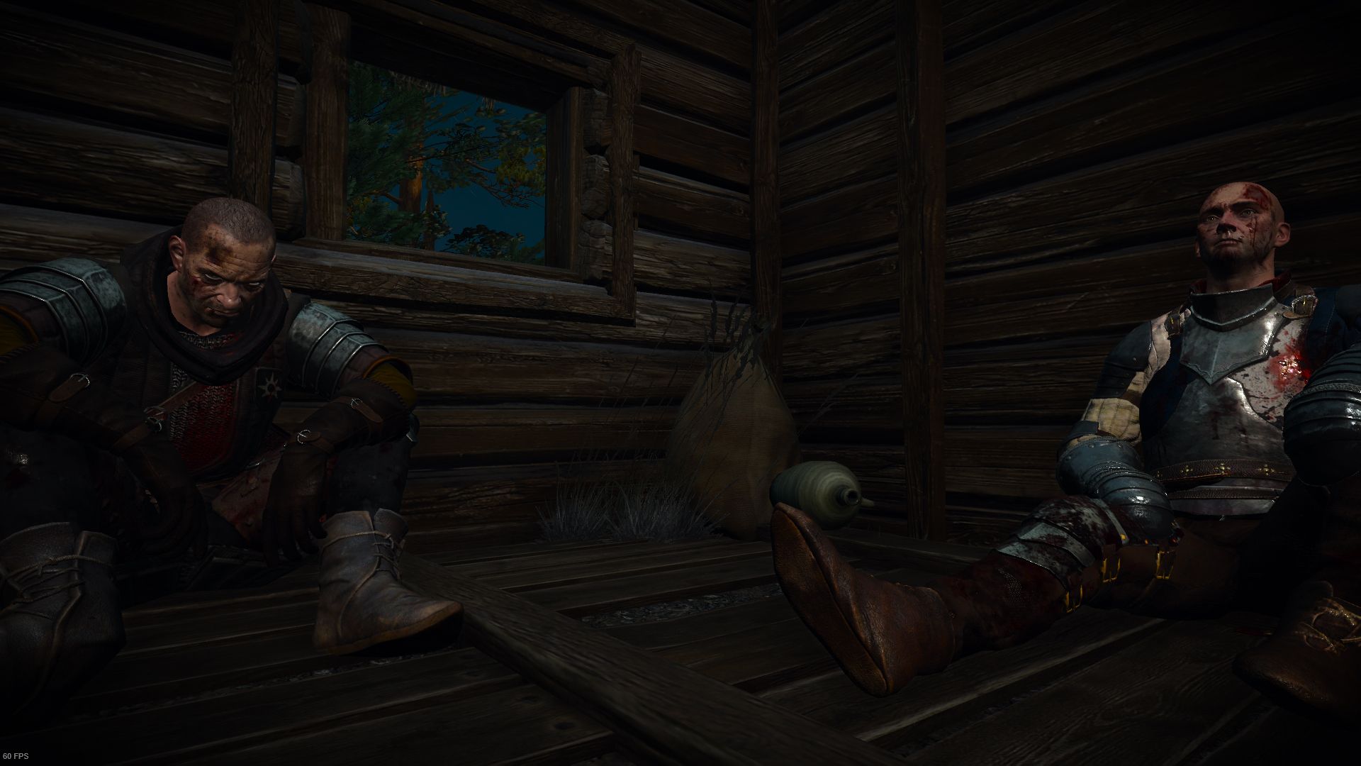 A pair of men shelter in an abandoned hut, covered in blood and damaged armor.