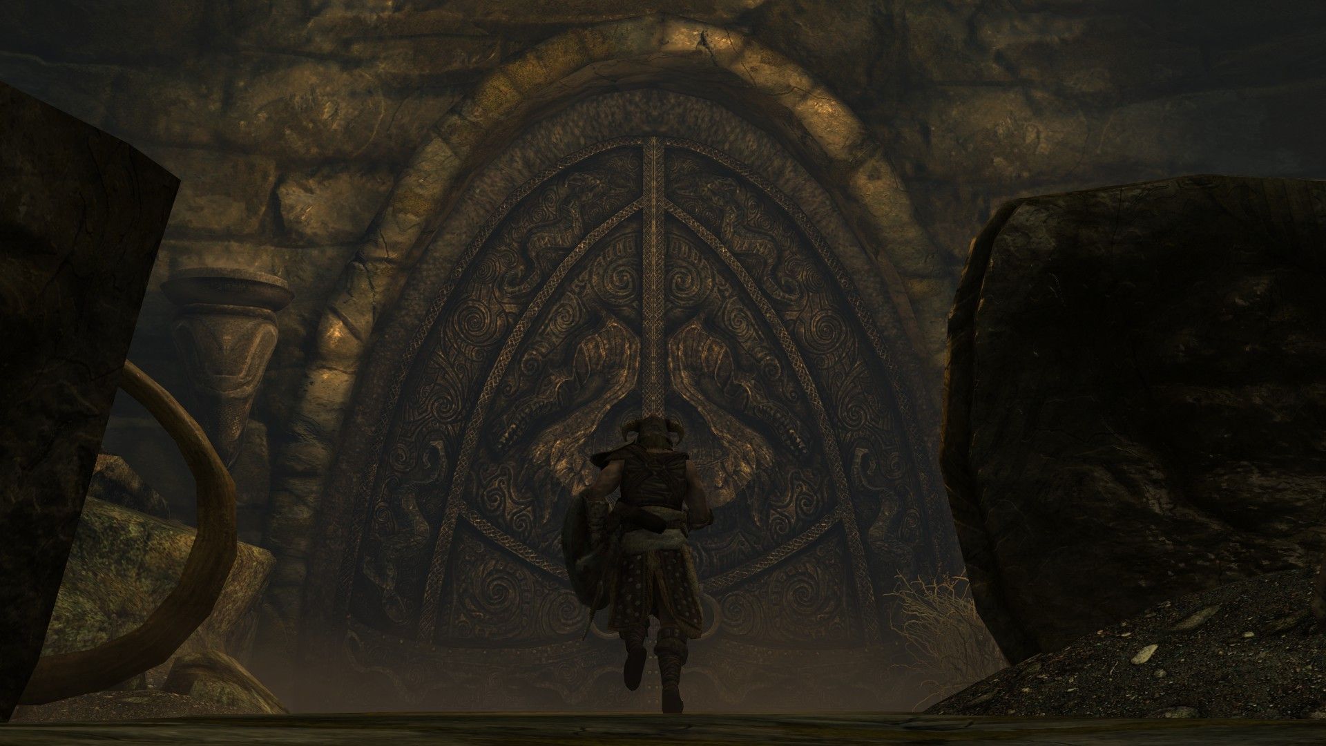 A man sprints toward an imposing door inside a dungeon.