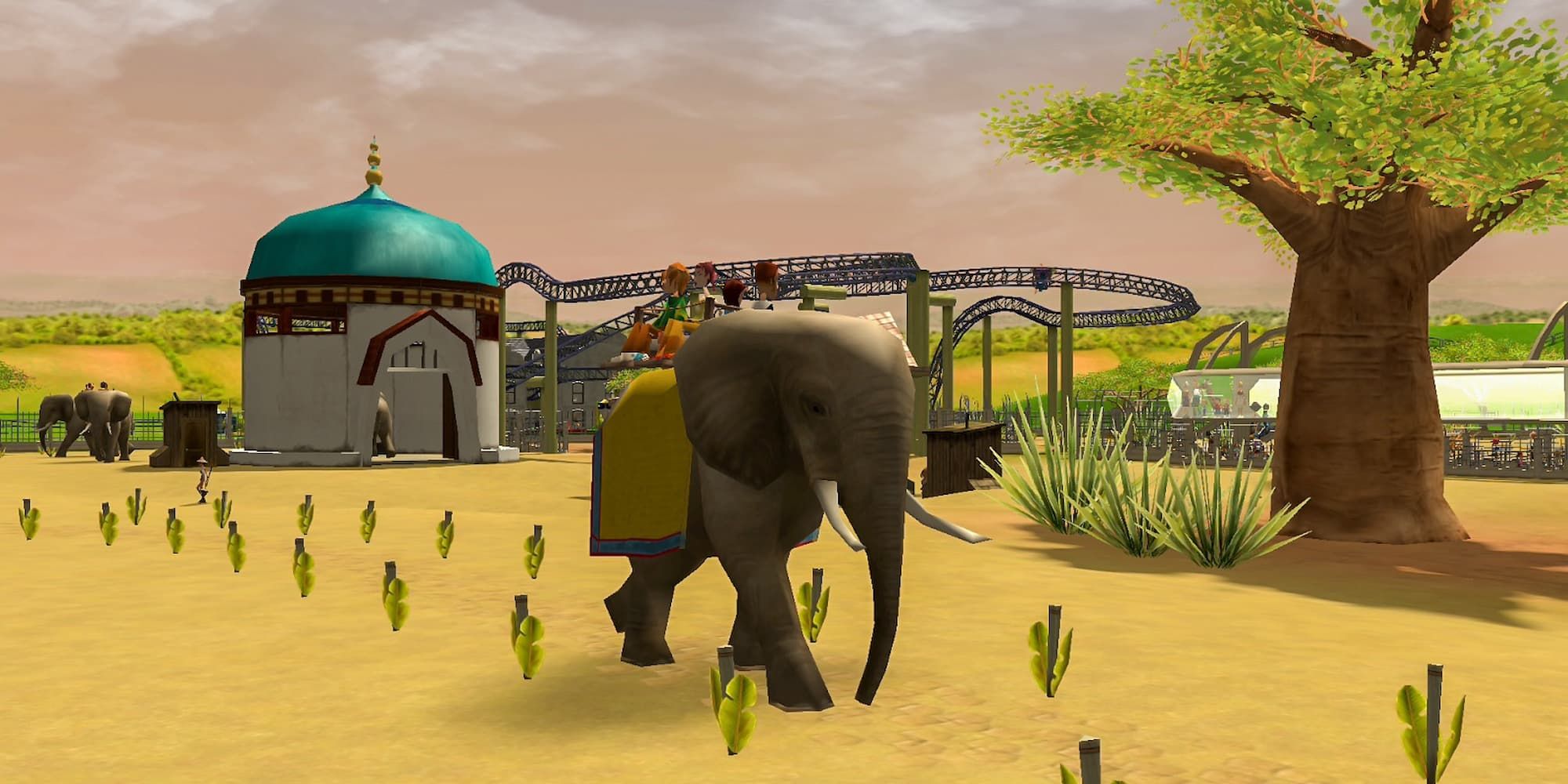 An elephant walks through the park in the Wild! expansion for RollerCoaster Tycoon 3.