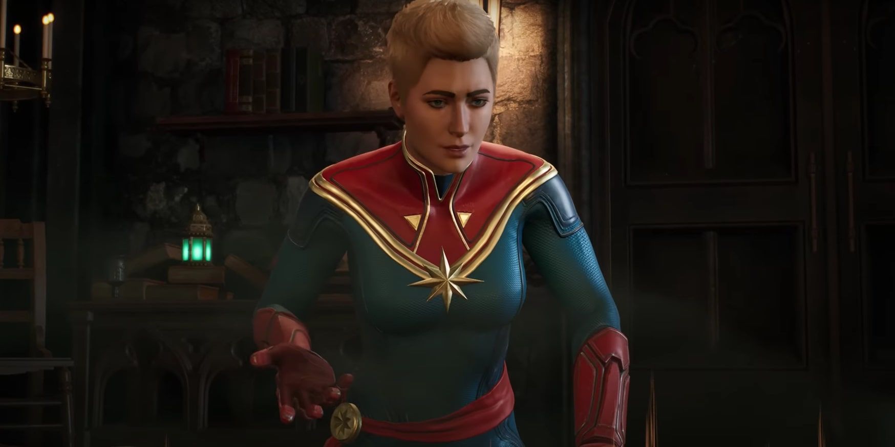 Captain Marvel looking down at the virtual map table of the Caretaker's in The Abbey.