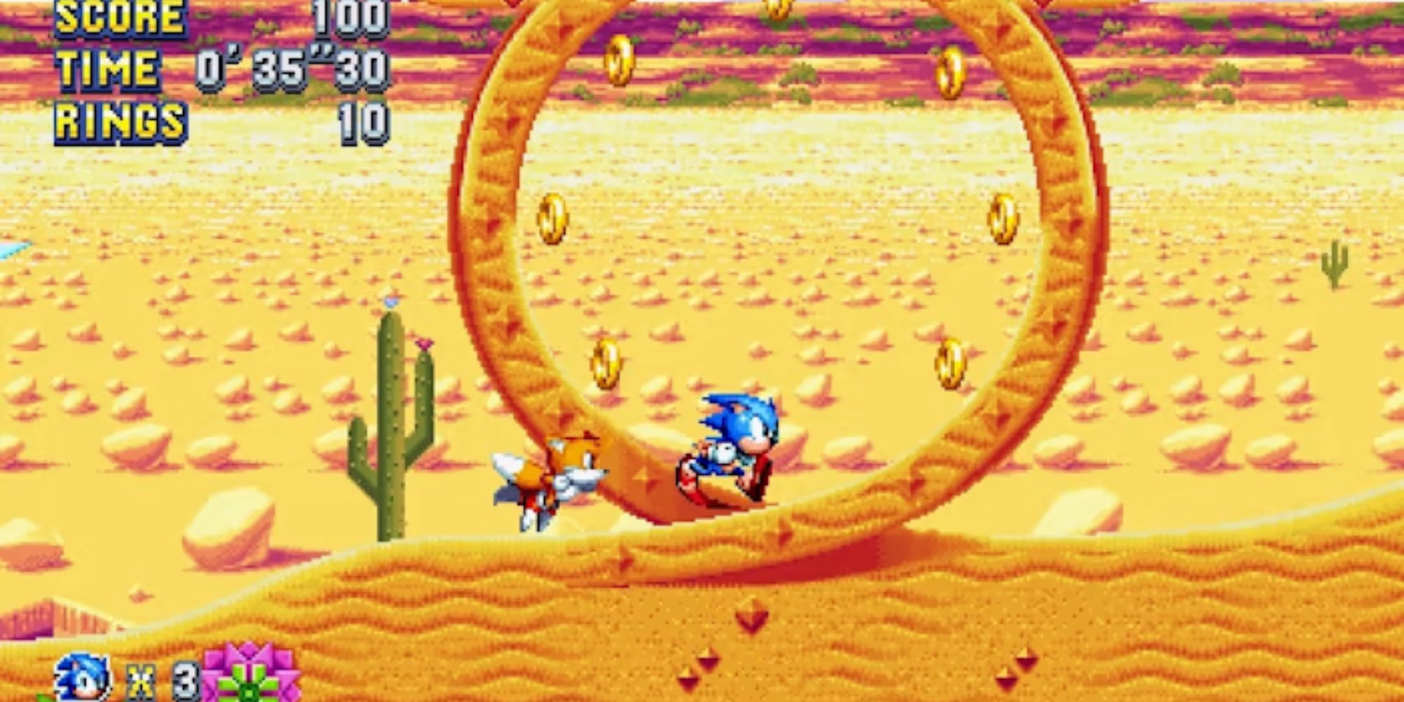 Sonic and Tails run towards a loop in the desert.