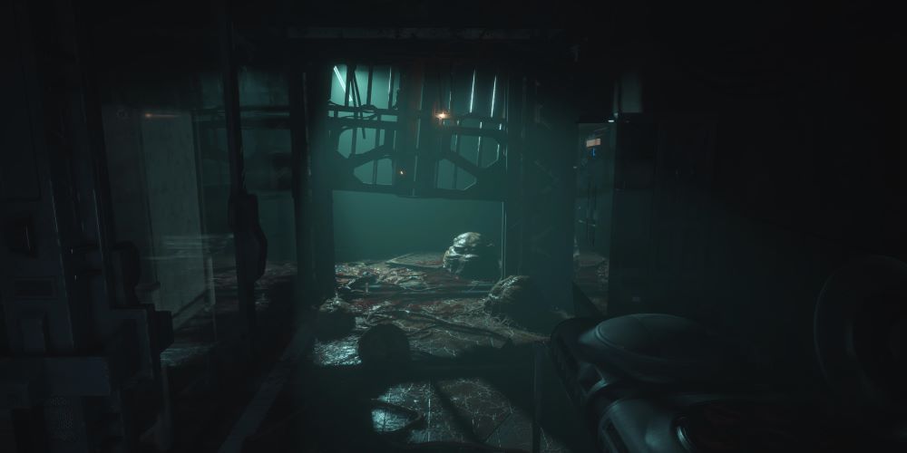Dark room with bodies and alien sacks on the floor
