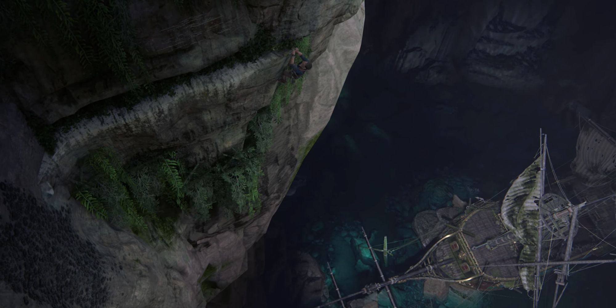 Nathan Drake climbing in a huge open cavern with Henry Avery's Shipwreck below in Uncharted 4: A Thief's End