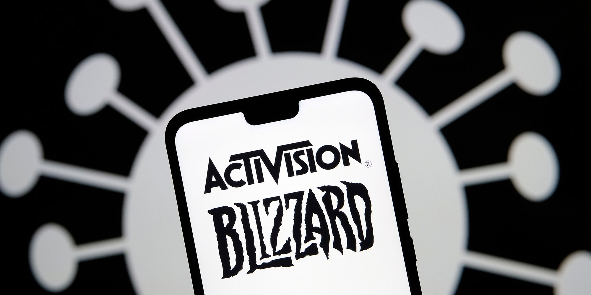 Activision Blizzard logo on a mobile phone against a black background with a white circle dividing into white lines ending with more white circles