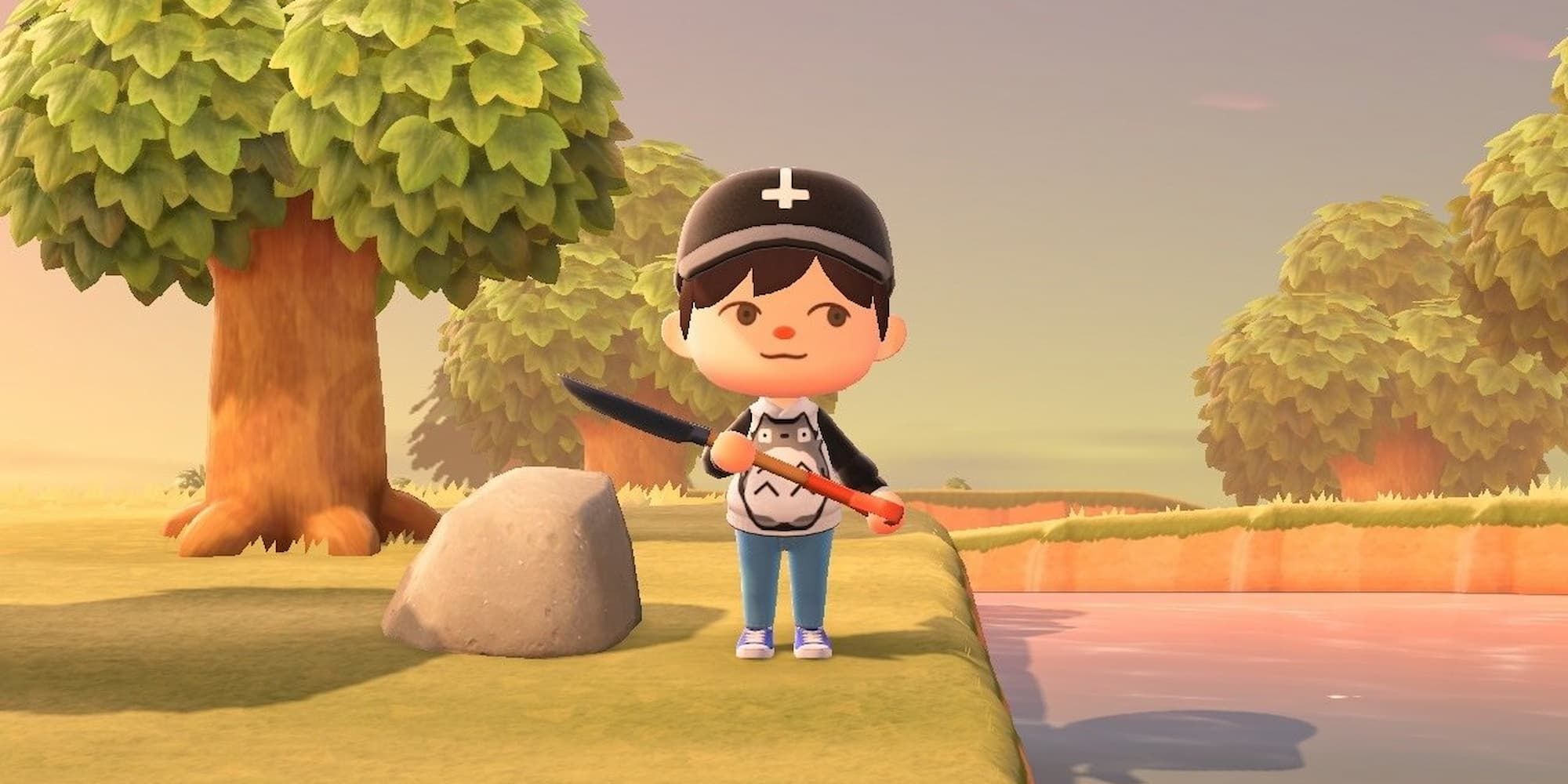 A human in Animal Crossing: New Horizons holds a shovel while standing between a stone and a river.