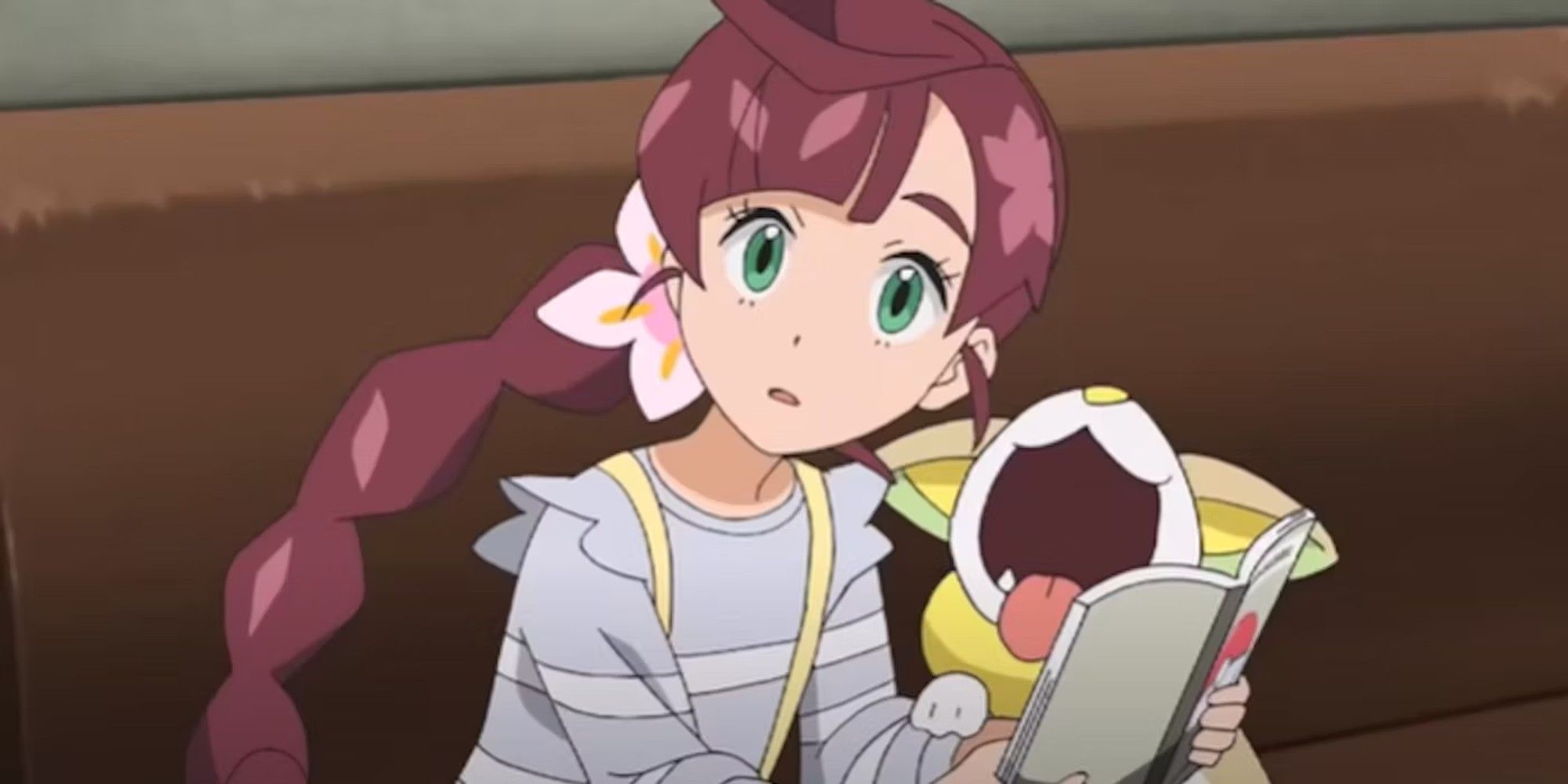 Chloe from the Pokemon Anime with her Yamper, reading a book