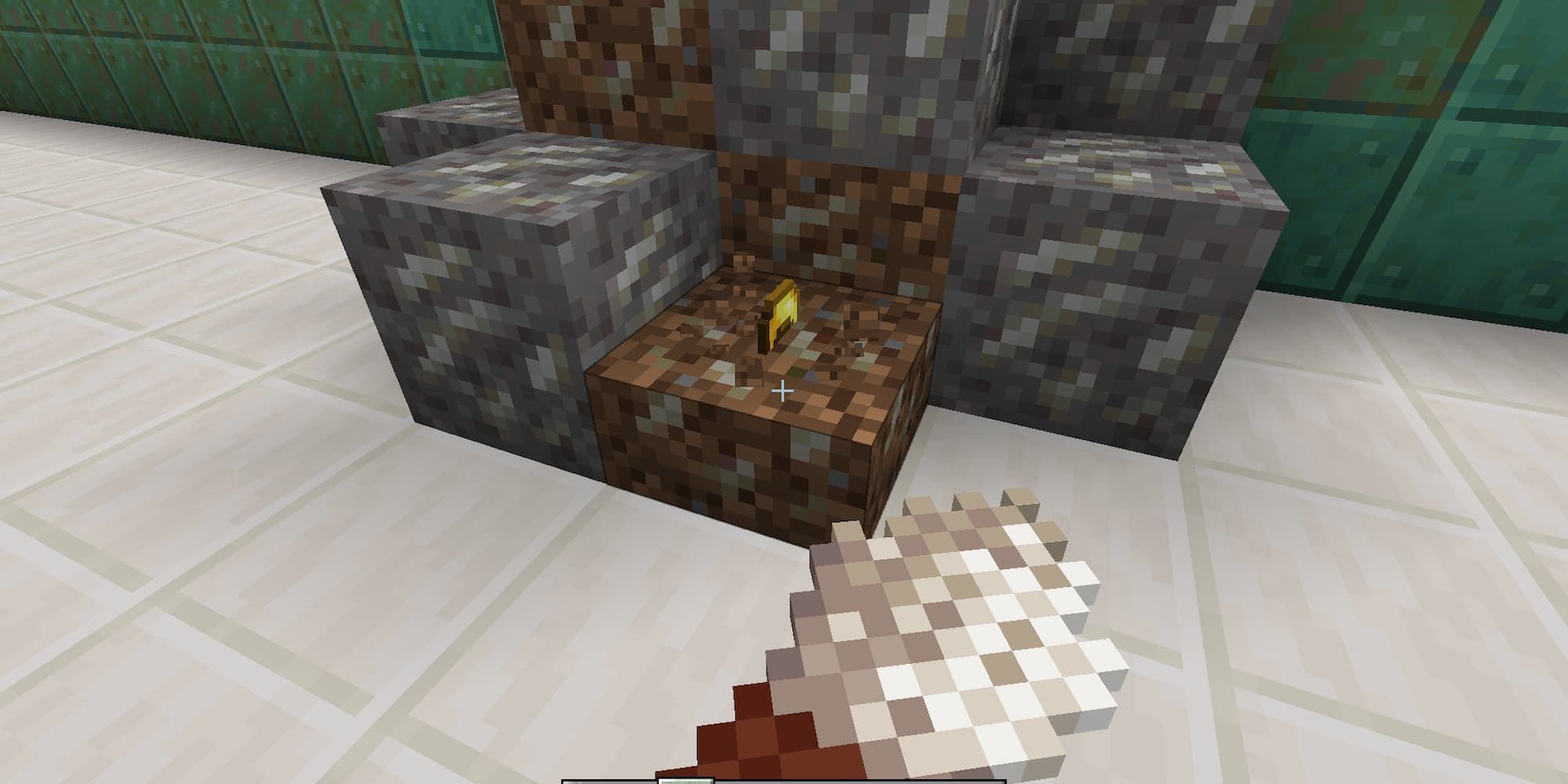 A player has used a brush on a dirt block in Minecraft to uncover something golden.