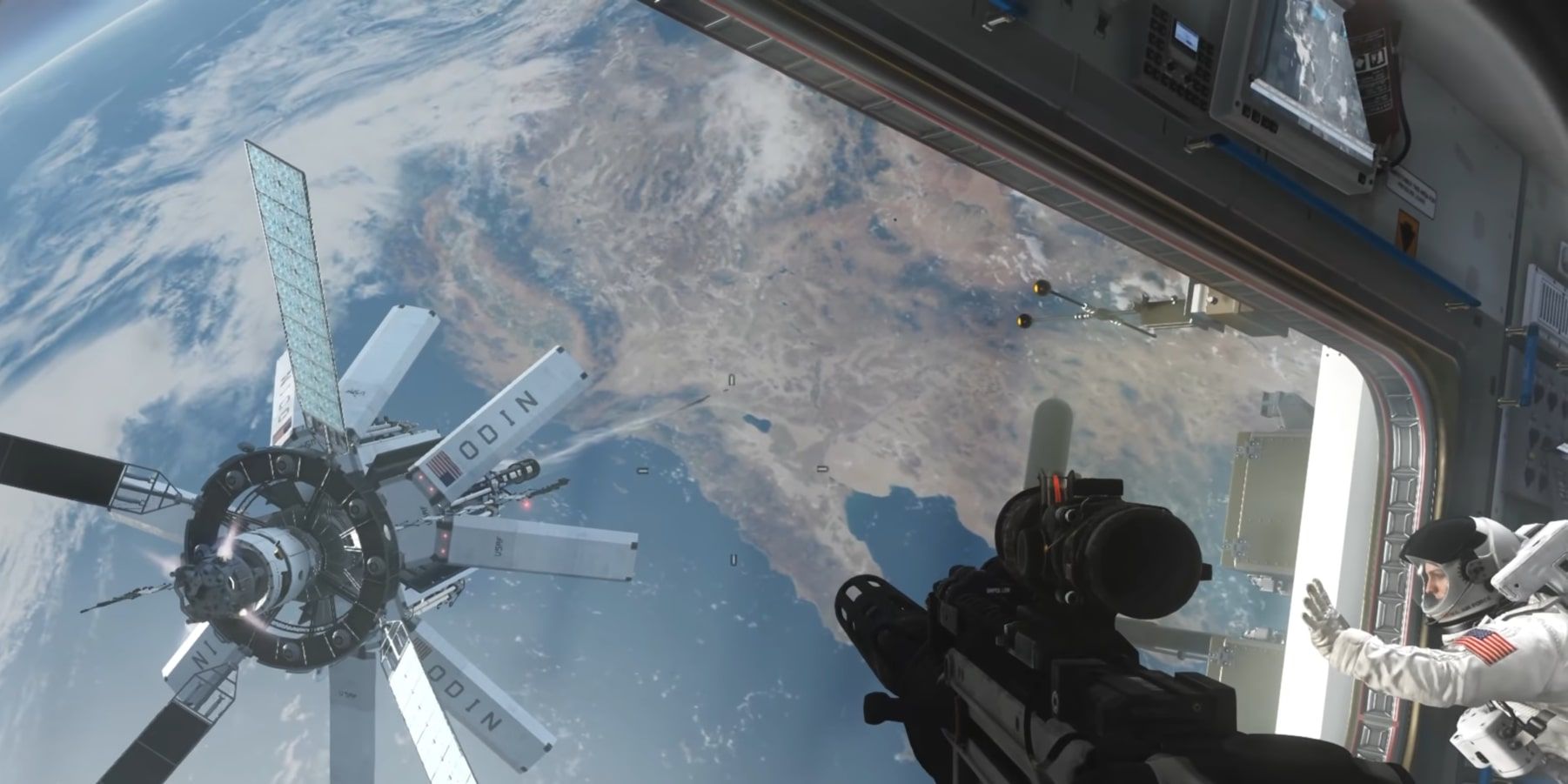 The main player character wielding an assault rifle near a partnering astronaut as they look at ODIN from a window.