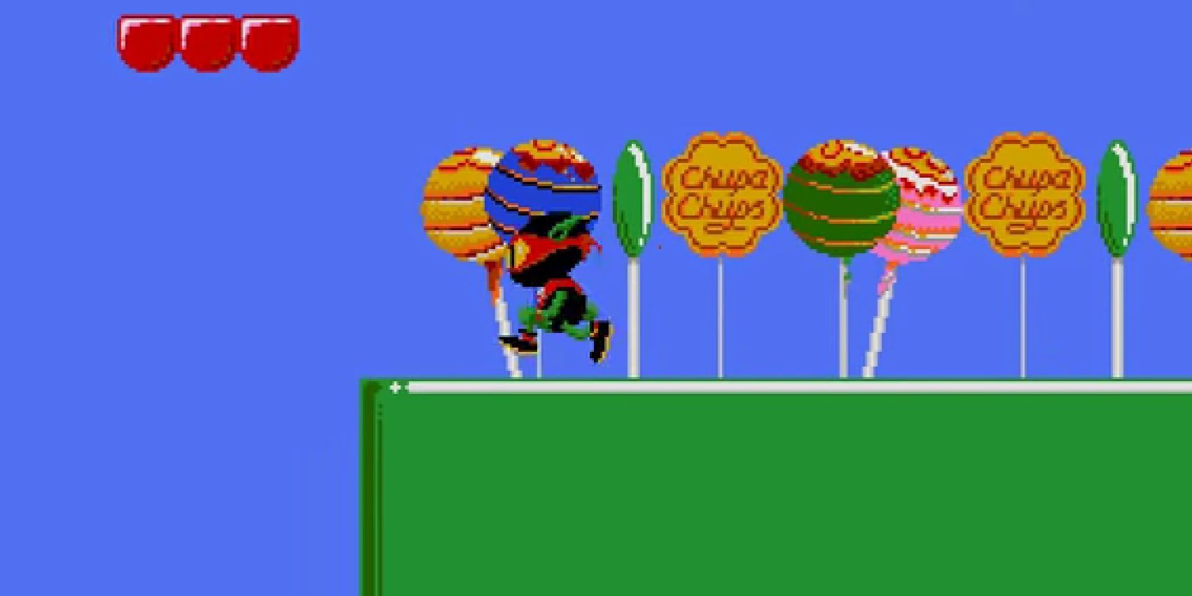 The titular character walking past a series of lollipops with the Chupa Chups wrapper and the brand logo on a platform.