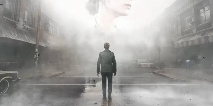 James looking up at a large apparition of Mary's face on the empty foggy streets of Silent Hill