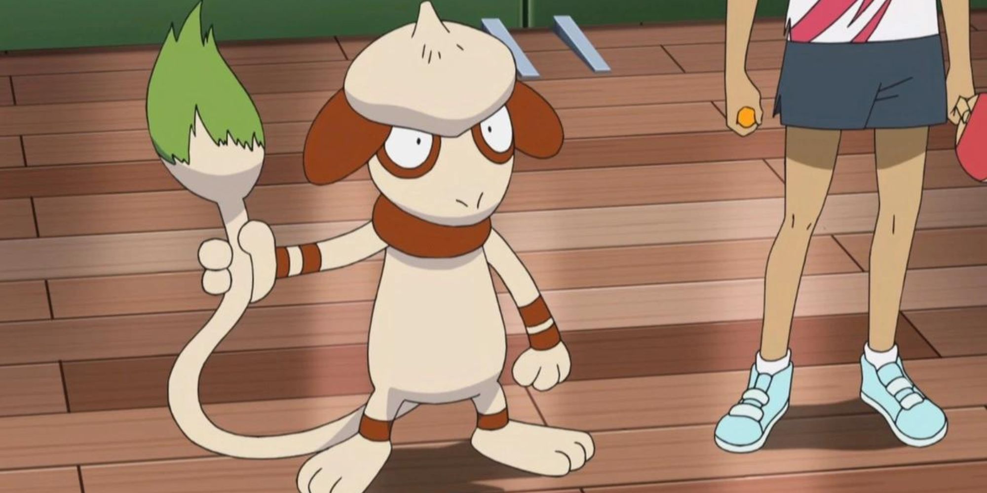 A Smeargle holds its tail next to a trainer who is holding a ping pong ball and paddle