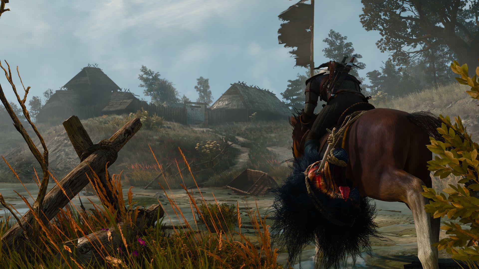 Geralt rides toward an inn by a road through a swamp on a cloudy day.