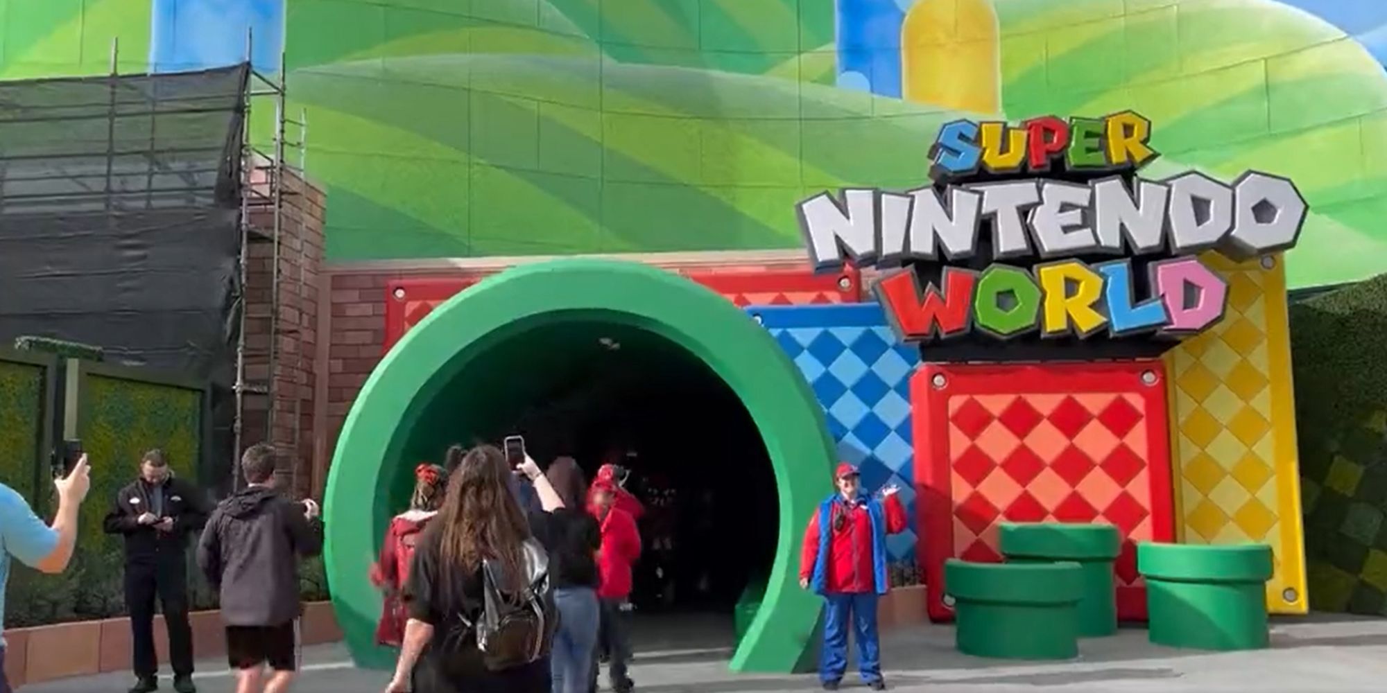 The Super Nintendo World entrance, showing visitors entering through a large green pipe with a colourful backdrop.
