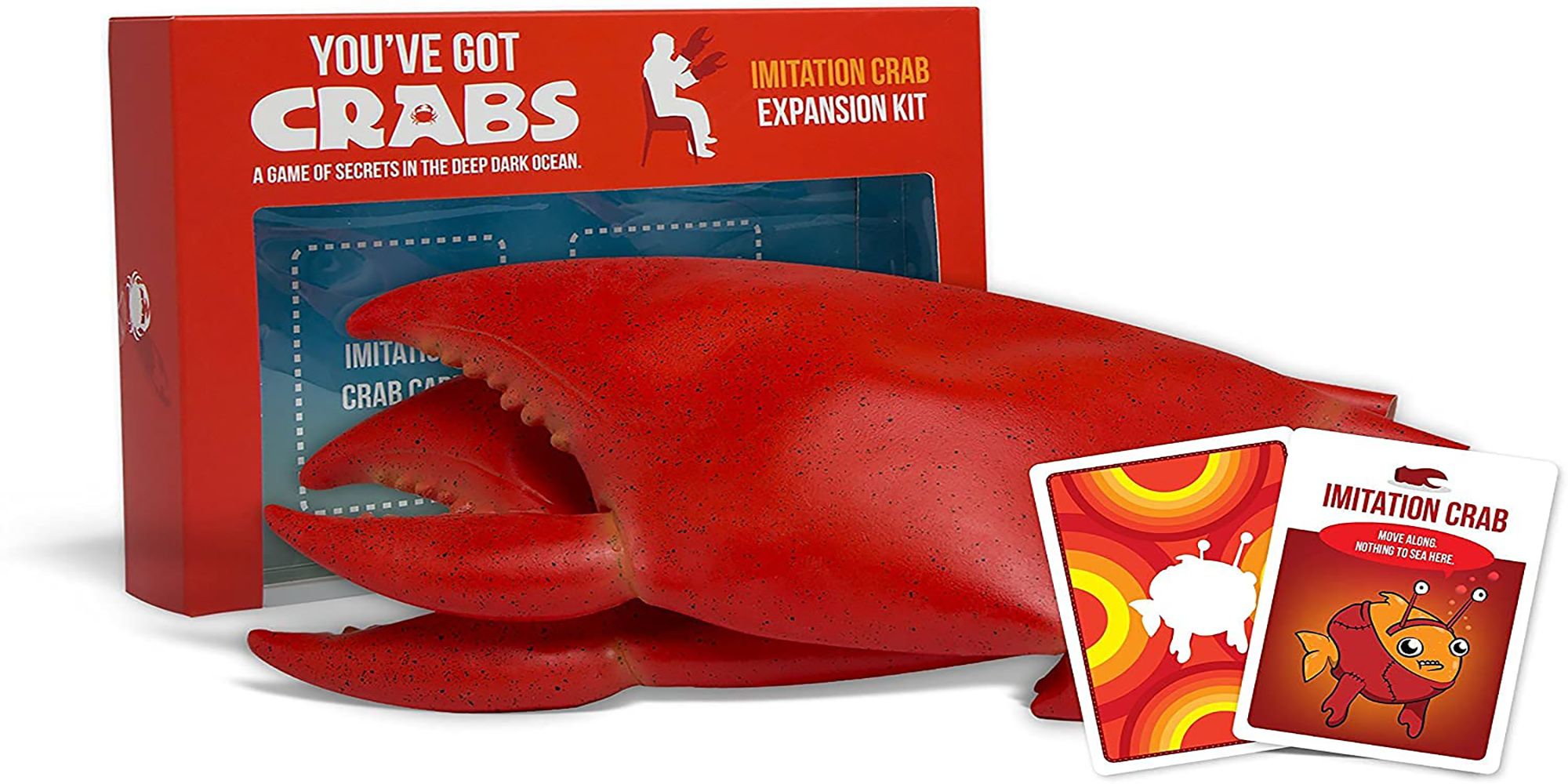A giant pair of crab claws and two "Imitation Crab" cards sit in front of the You've Got Crabs Expansion kit.