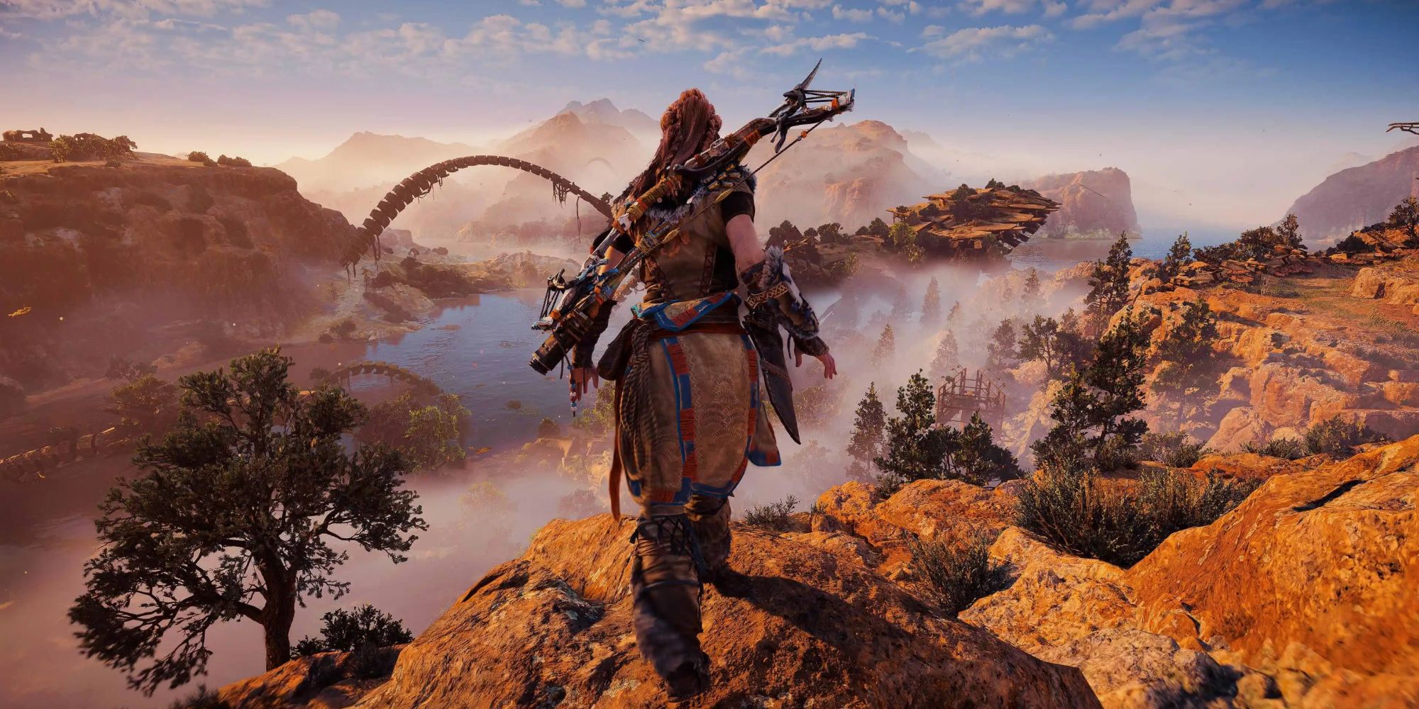 Aloy looking out at a gorgeous view from the top of a cliff in Horizon Forbidden West