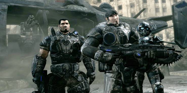 Dom, Marcus and Carmine holding Lancers in front of a helicopter in Gears of War