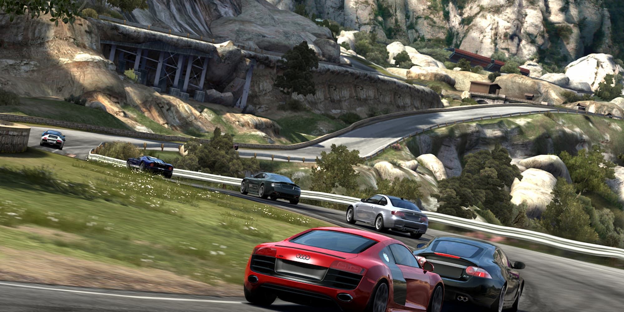 A line of cars race around a curve in a mountain road in Forza Motorsport 3.