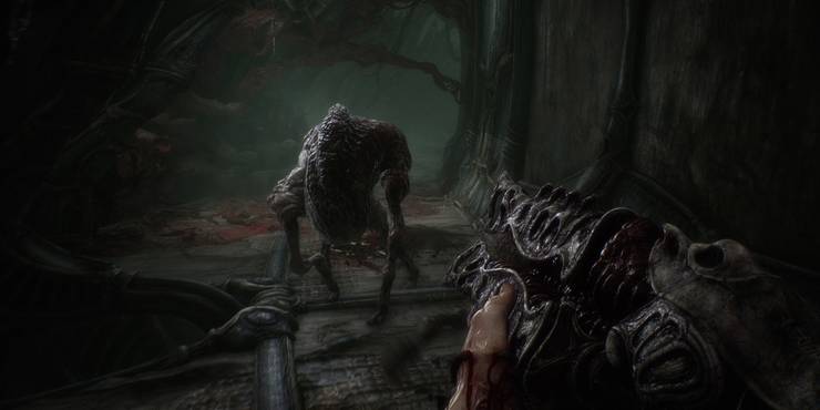Humanoid protagonist pointing gun at creature in Scorn