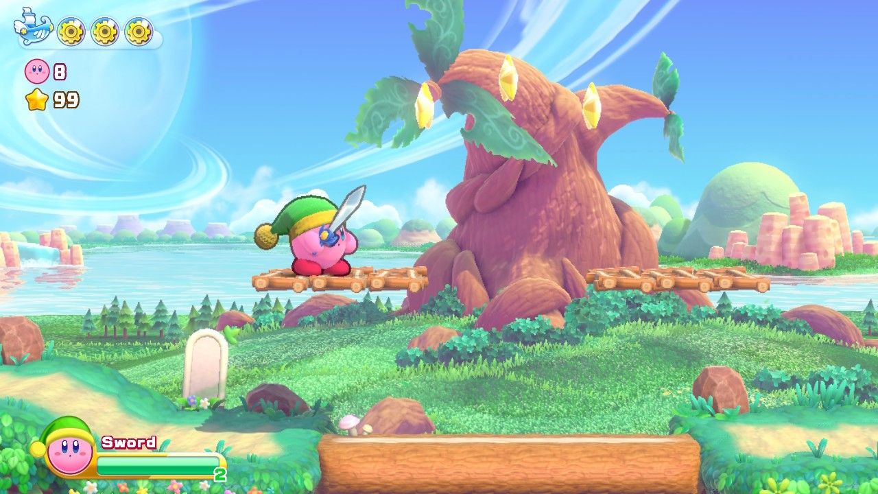 Кирби на уступе собирается прыгнуть, чтобы собрать арку из звезд в Стране печенья в Kirby's Return to Dreamland Deluxe.