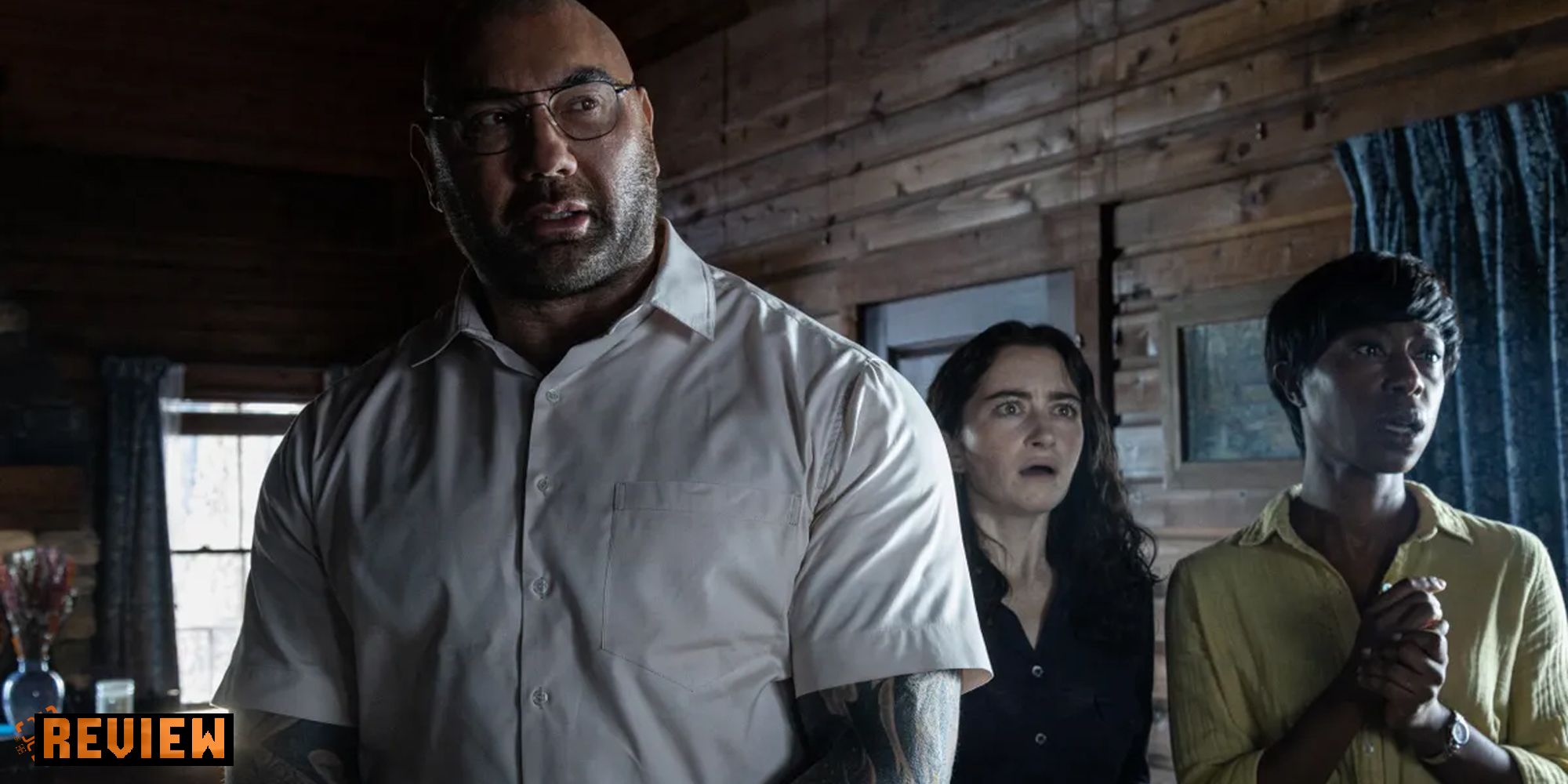Knock At The Cabin review image with Dave Bautista, Abby Quinn, and Nikki Amuka-Bird.