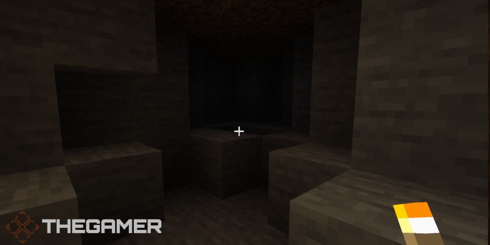 A dark cave and a torch that illuminates it