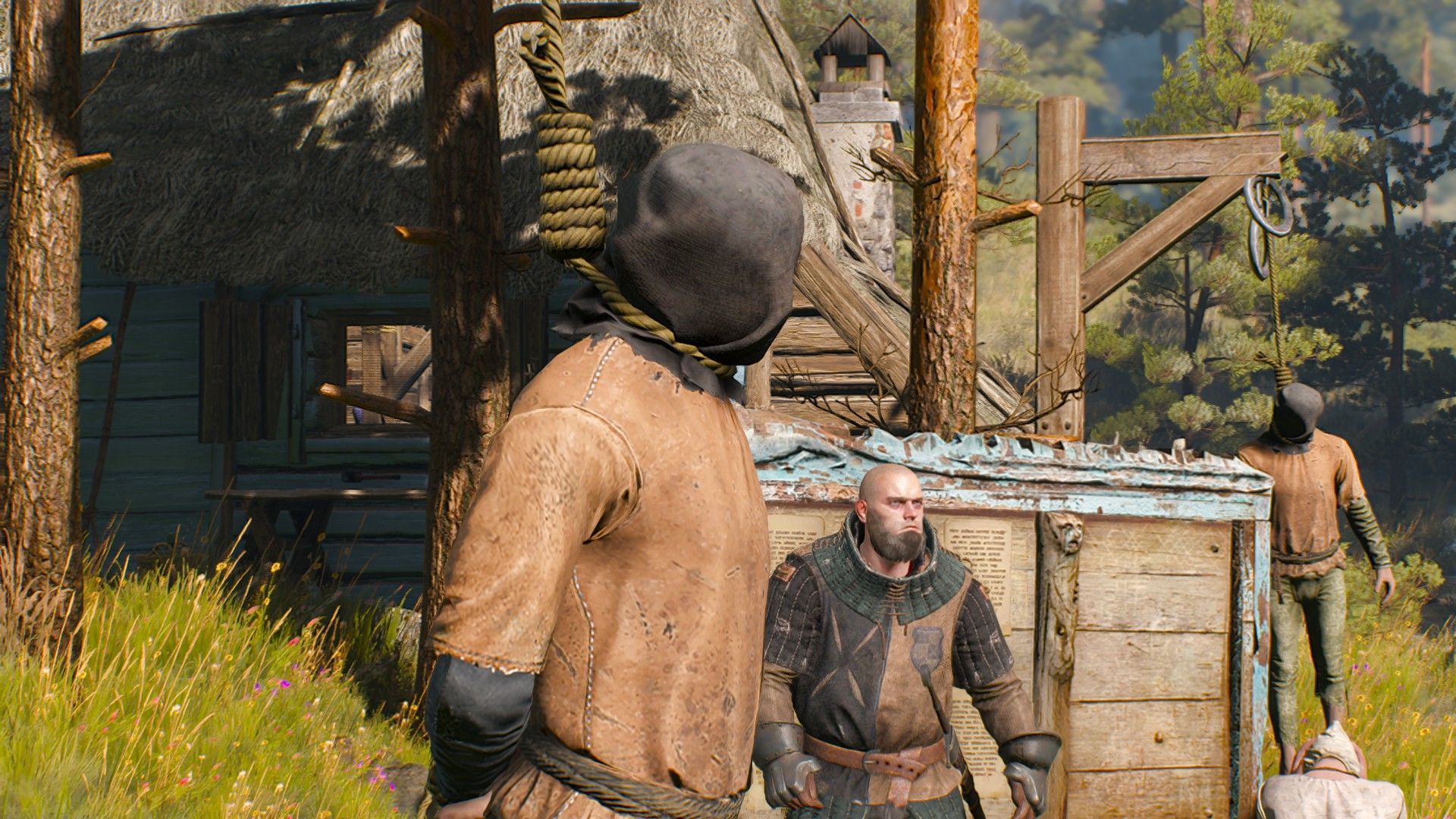A body dangles on a noose in an ancient village with a thug standing in the background.