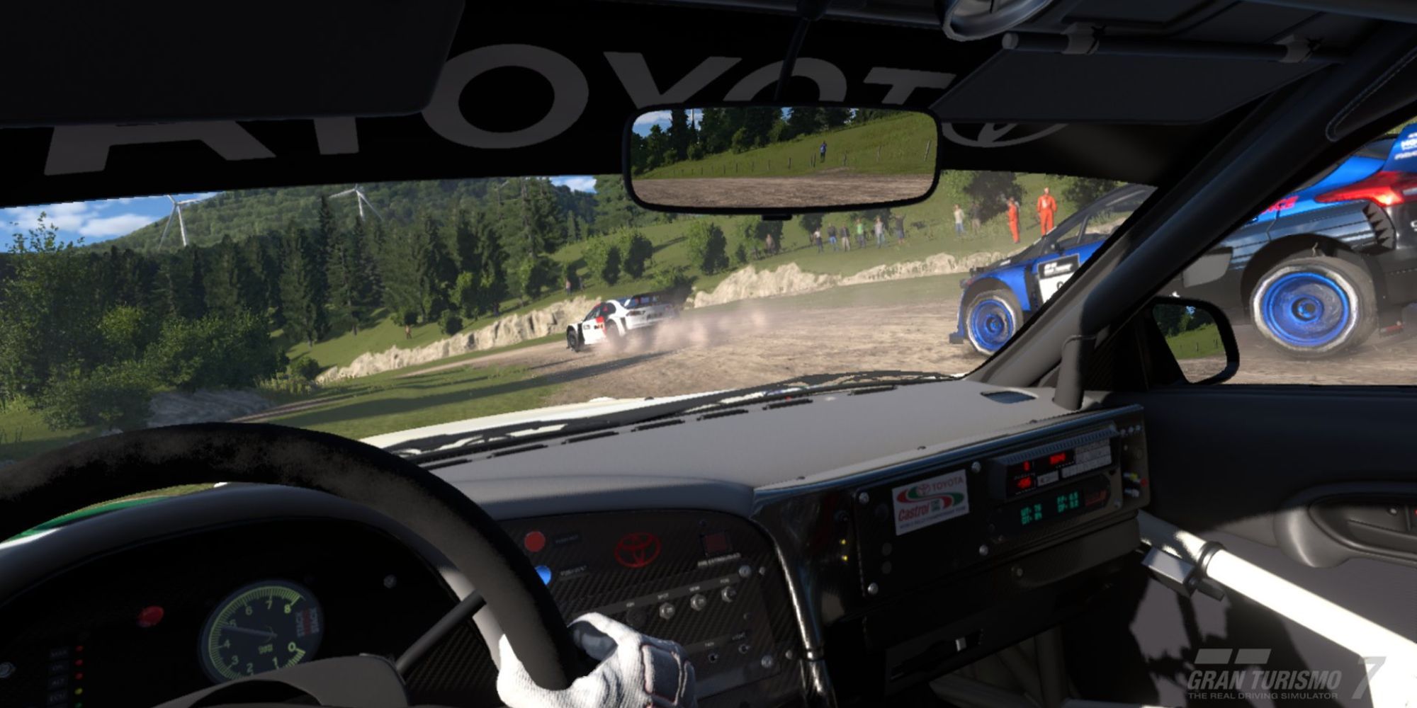 An image from Gran Turismo 7 showing the driver's perspective from inside a rally car on a rally track