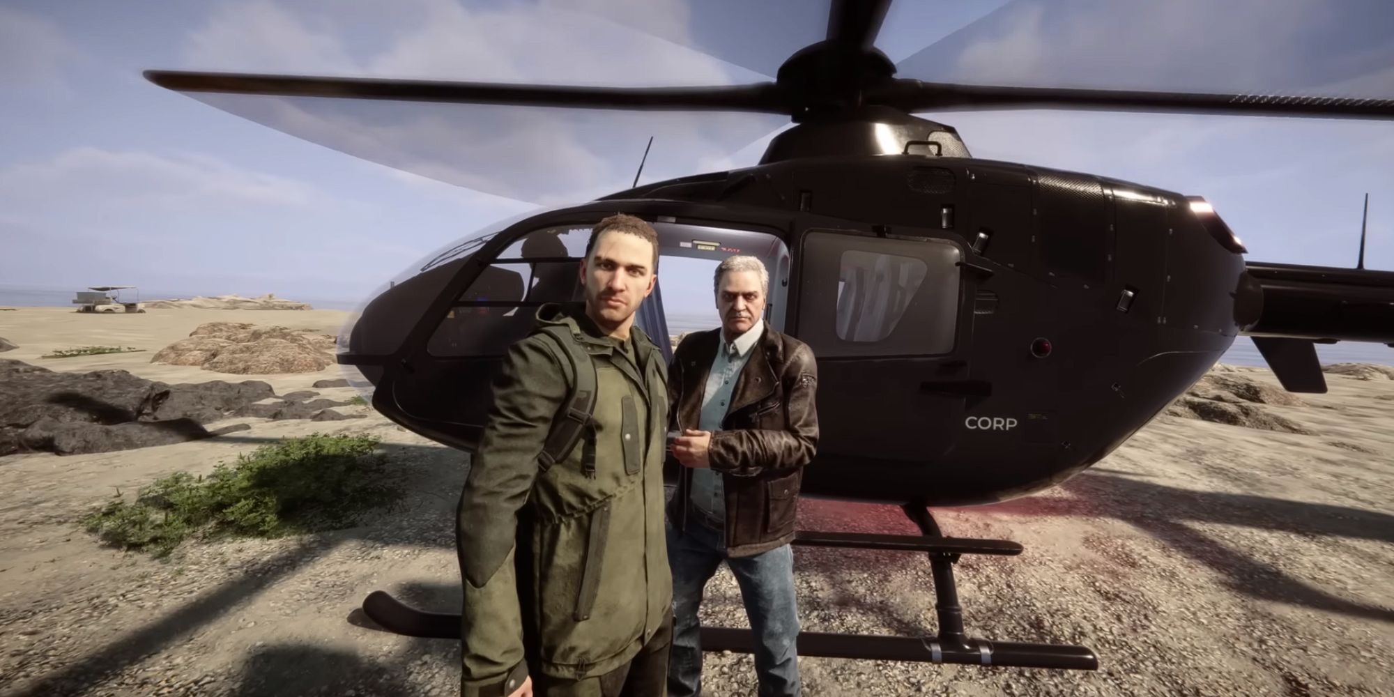 A young man and an older gentleman stand in front of a helicopter that has landed on the beach