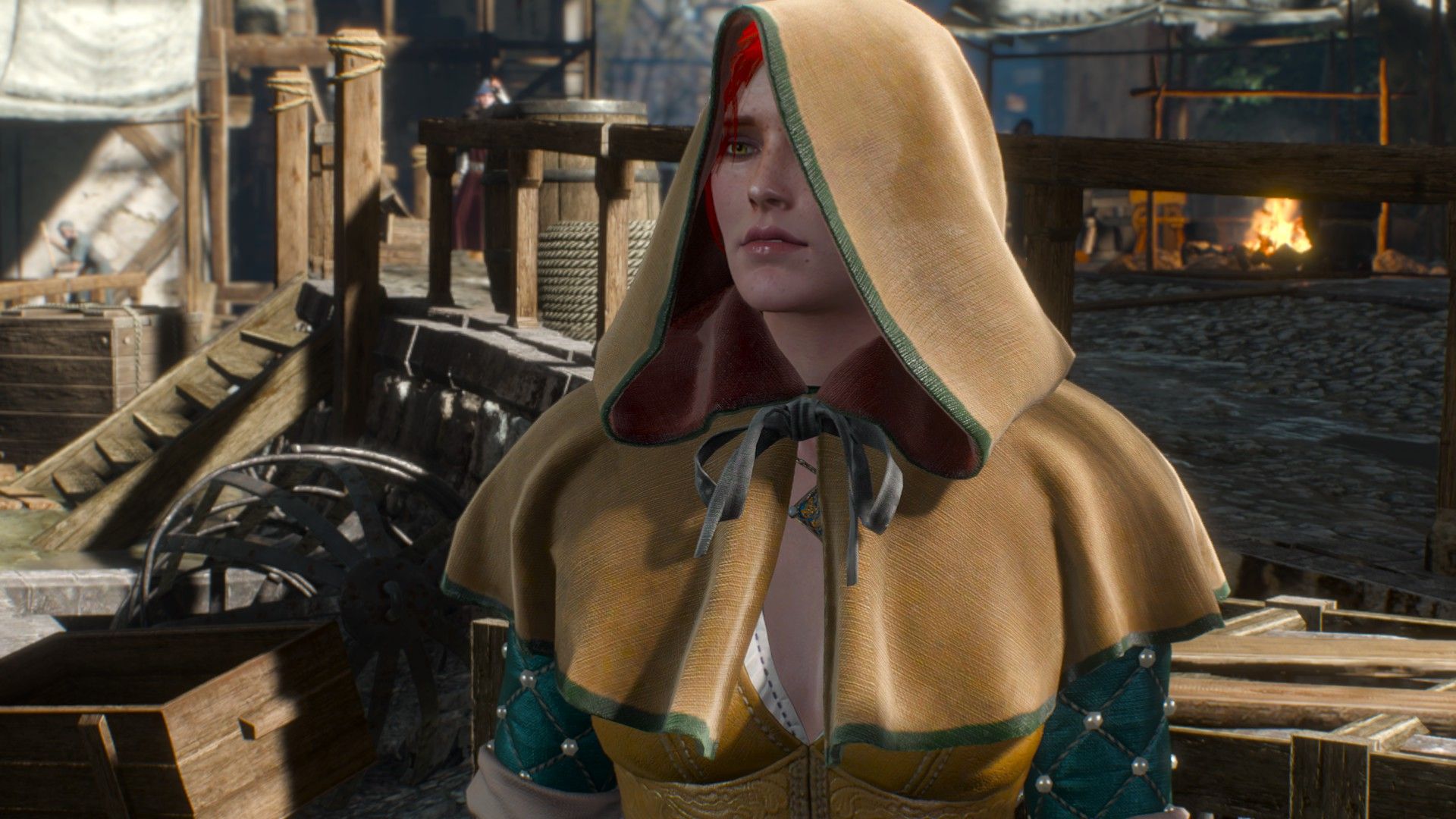 Triss Merigold stands in the middle of a medieval city wearing a hood to disguise her identity.