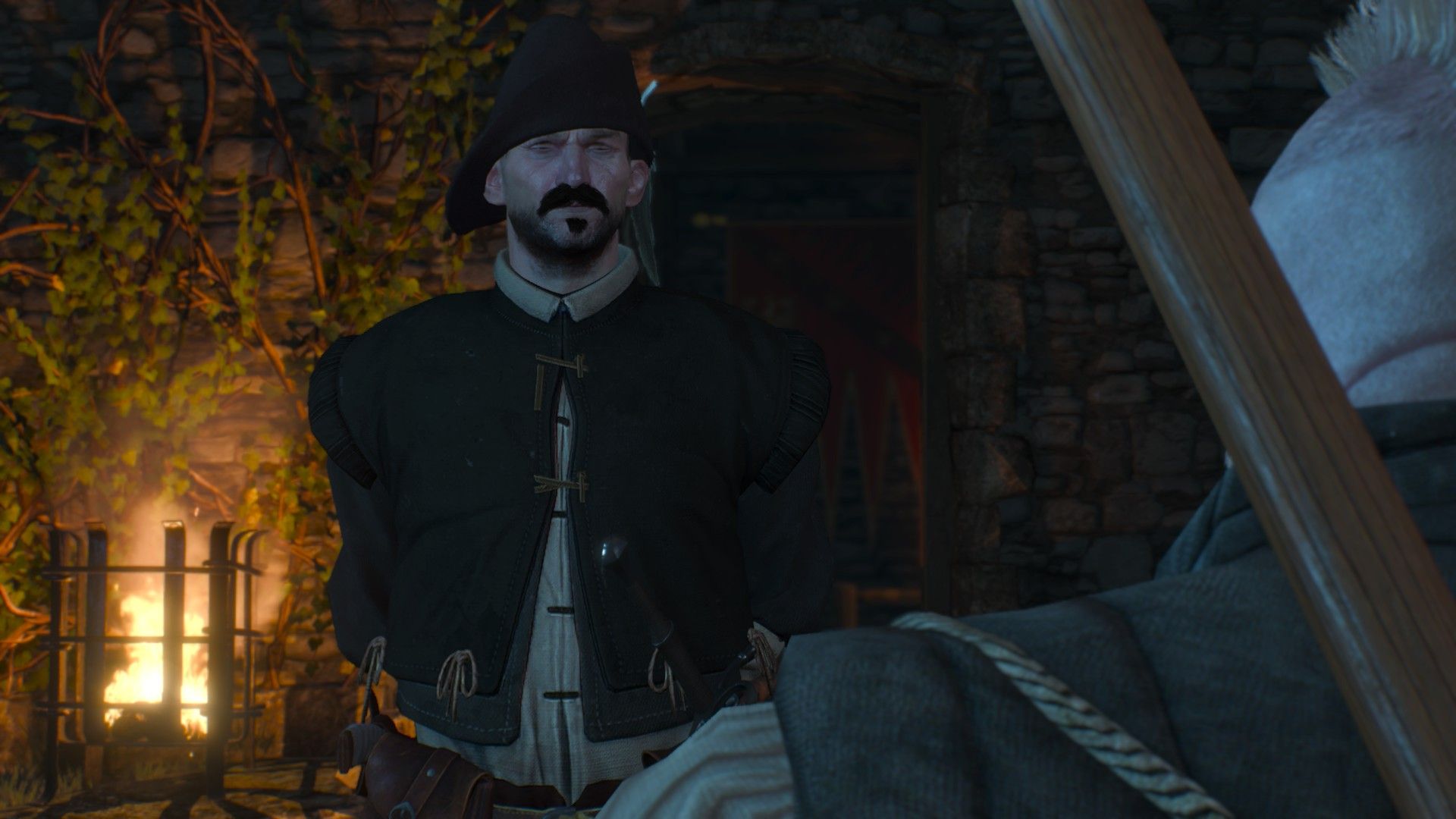 A man dressed in a dark jerkin and matching cap makes a snide remark to Zoltan at night in The Witcher 3.