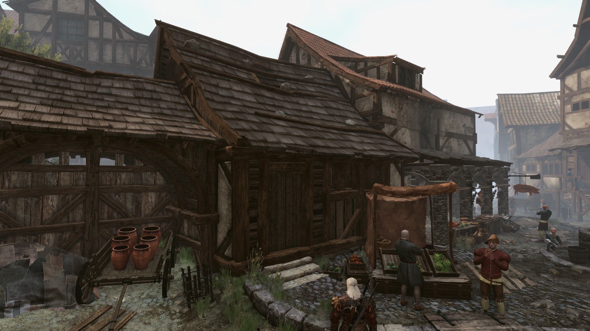A wide-angle, overhead shot of Geralt standing outside an unassuming shop on a Novigrad street.