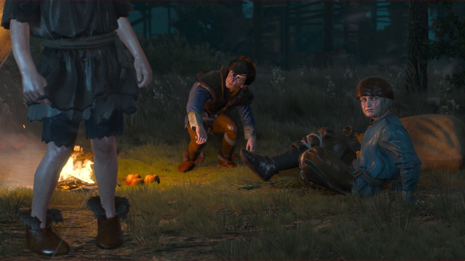 A trio of children rise to their feet next to a campfire in the woods at night.