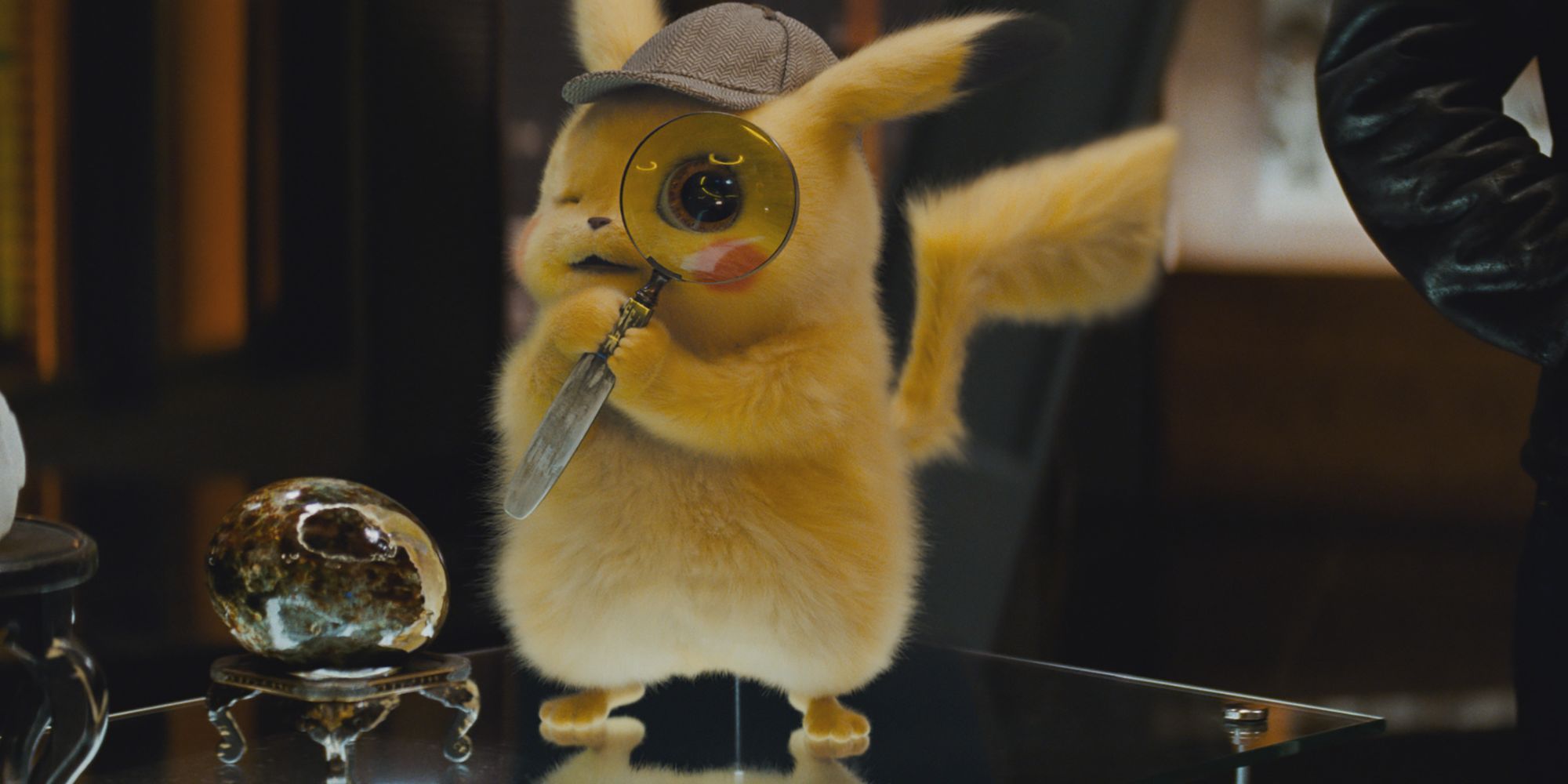 Detective Pikachu holds a magnifying glass to his eye