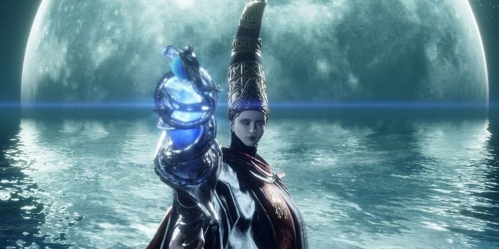 La reina Rennal sosteniendo un bastón alto frente a la luna llena en el videojuego Elden Ring