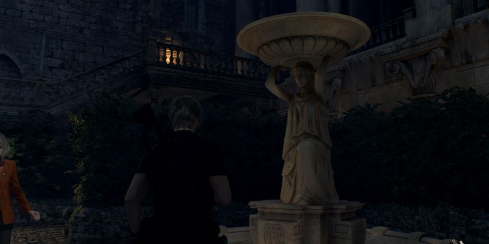 Leon Kennedy and Ashley Graham stop near a statue in the Caslte Salazar Courtyard in Resident Evil 4 Remake