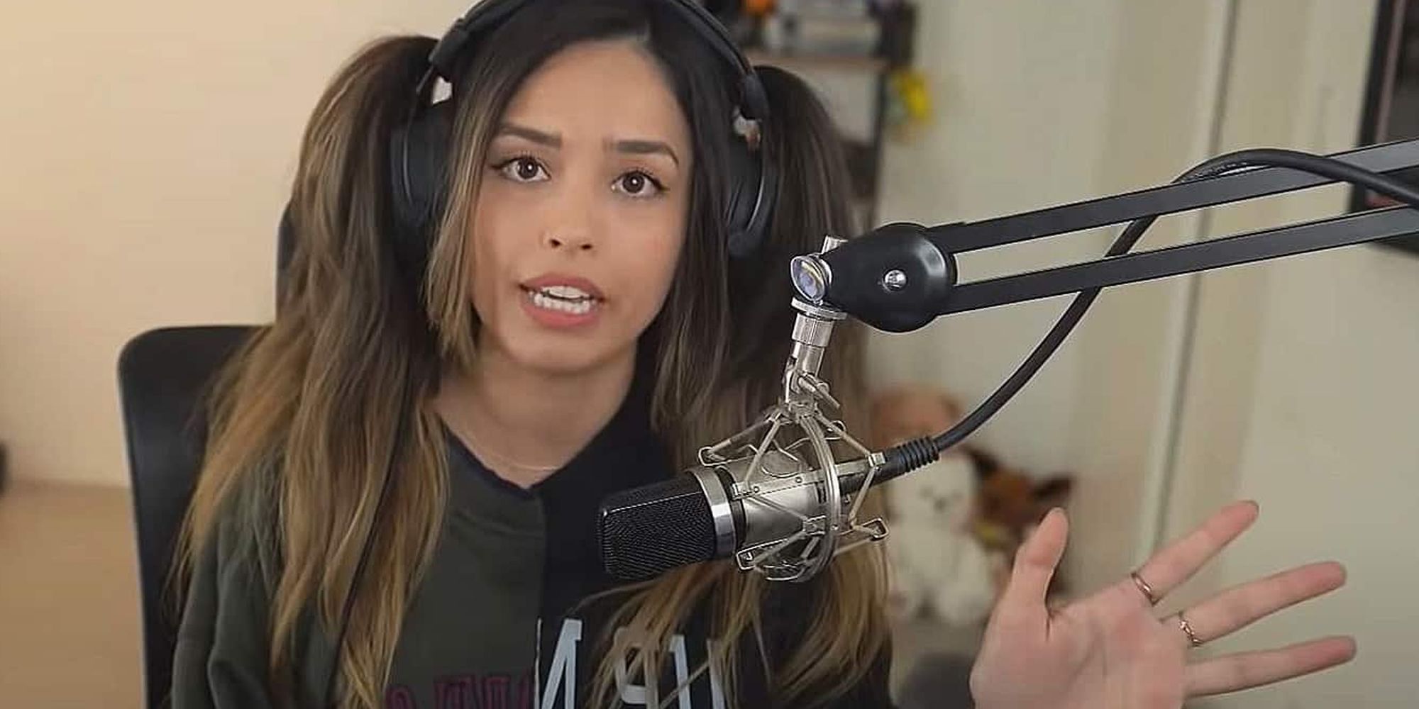 Valkyrae looking at the camera while speaking into a microphone during a stream
