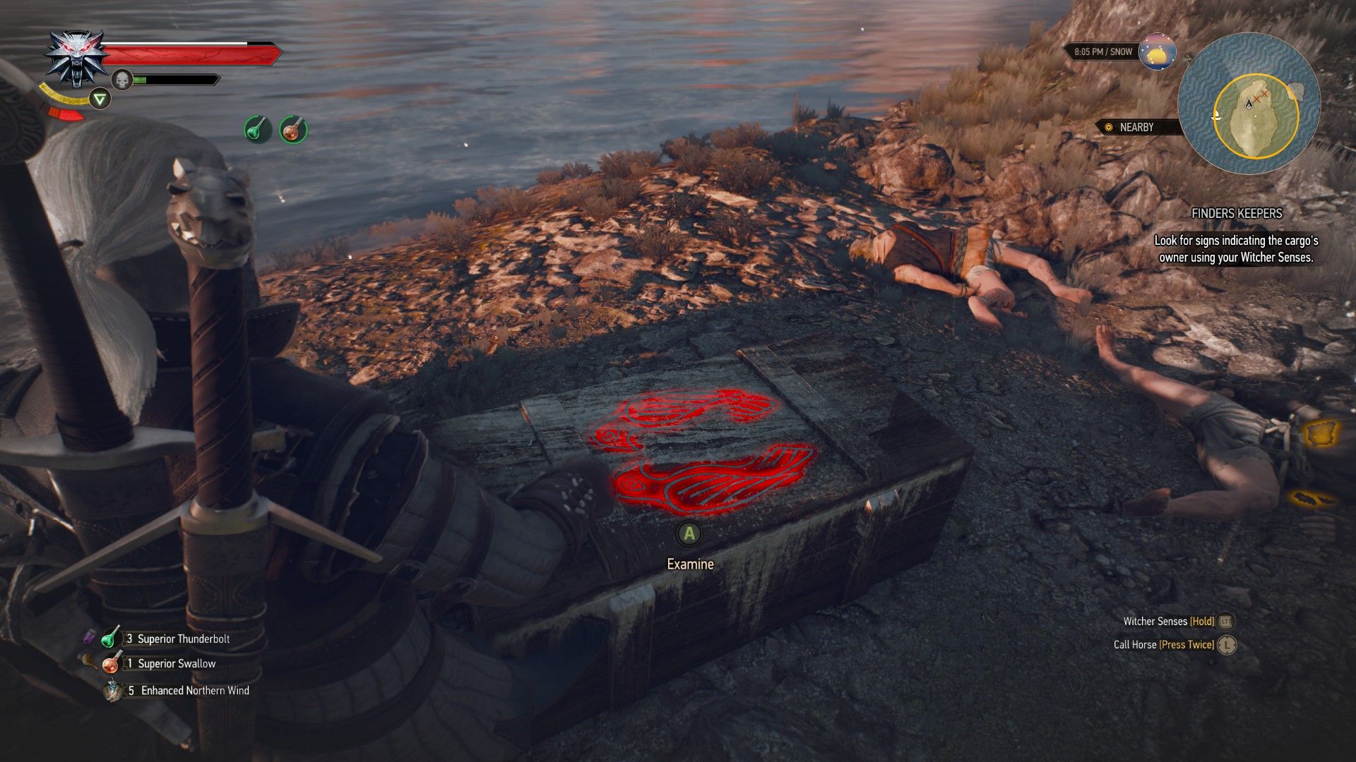 A screenshot of Geralt standing over a box with a clan emblem engraved on it.