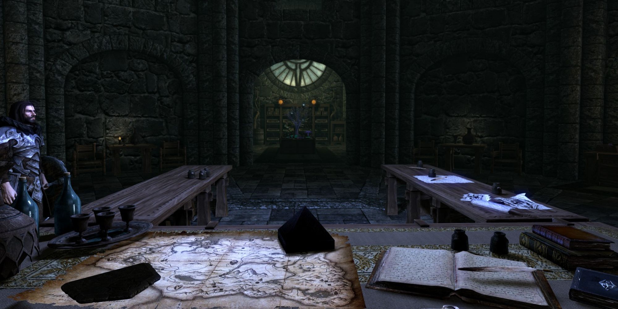 A view of the revamped Archmage's Quarters from the Archmage's seat on the long desk filled with notes, books, a map, and other clutter
