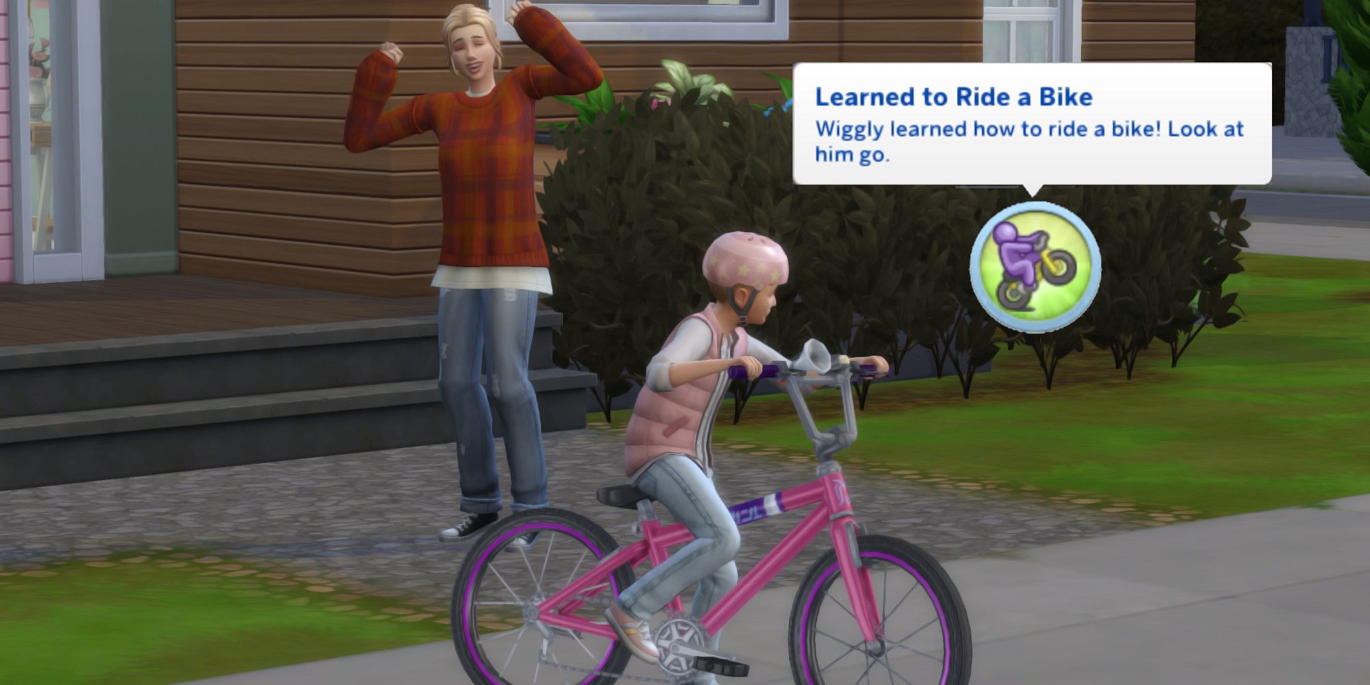 An adult Sim cheers on a child Sim as he rides a bike. A text bubble saying "Learned to Ride a Bike" is next to him.