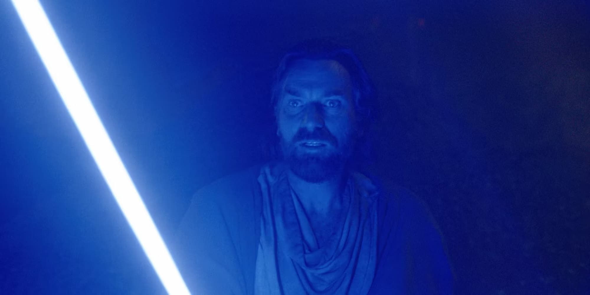 Obi-Wan Kenobi wields her blue lightsaber with a fearful expression on his face.