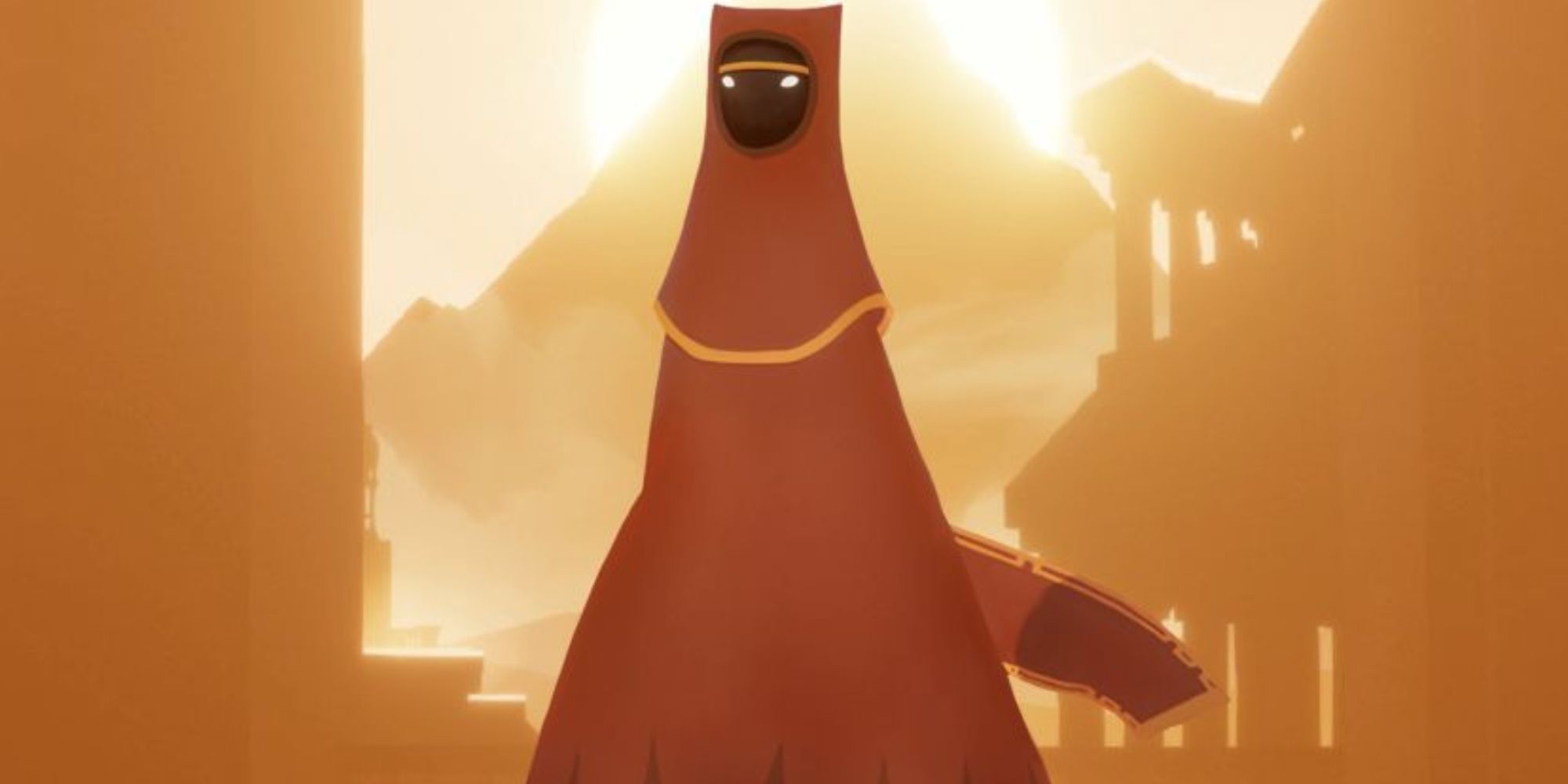 A close-up of the main red-cloaked protagonist of Journey with the face, and a bright brown landscape in the background.