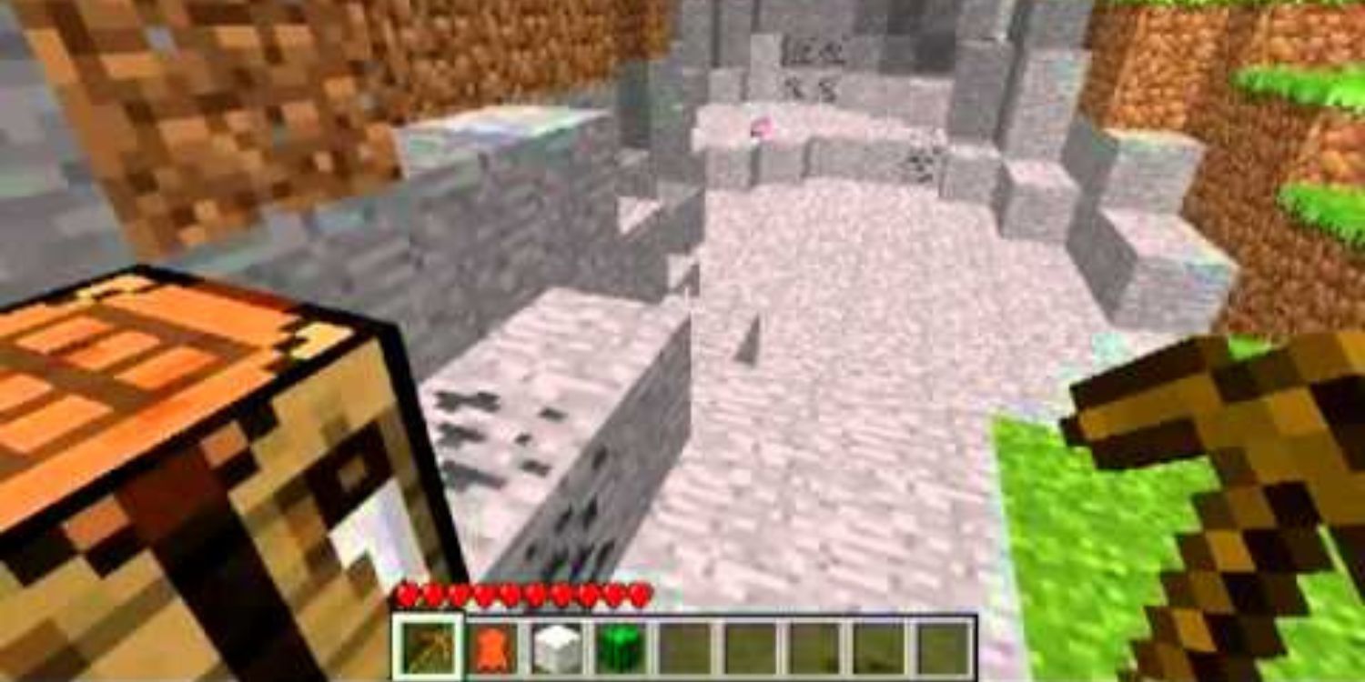 The player holding a pickaxe neat the entrance of a mine in Minecraft.